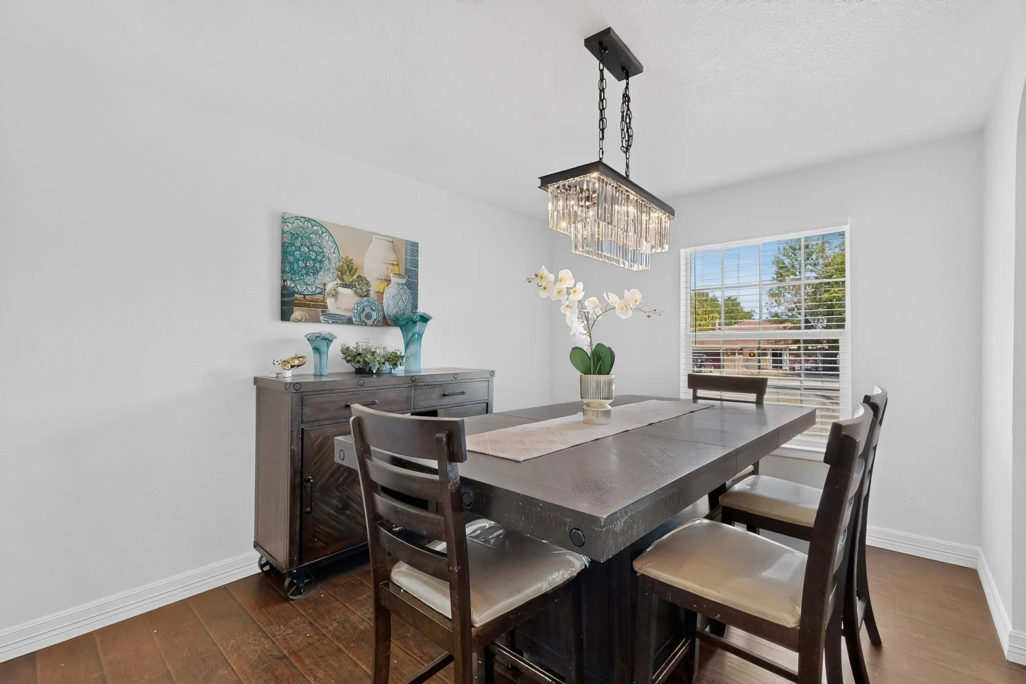 Recessed window, wood-finish flooring, and a crystal drop chandelier