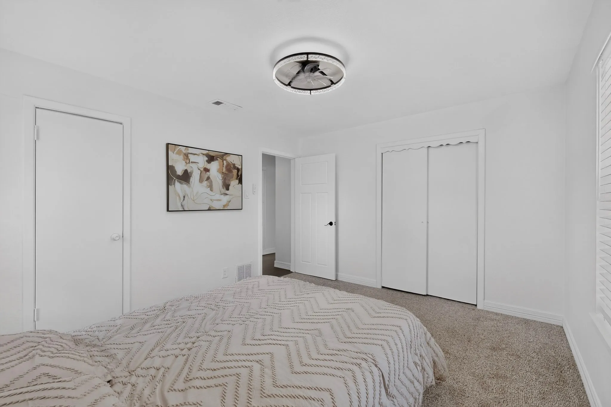 Neutral paint palette, plush carpeting, ceiling-mounted light fixture, white interior doors, and bi-fold closet doors