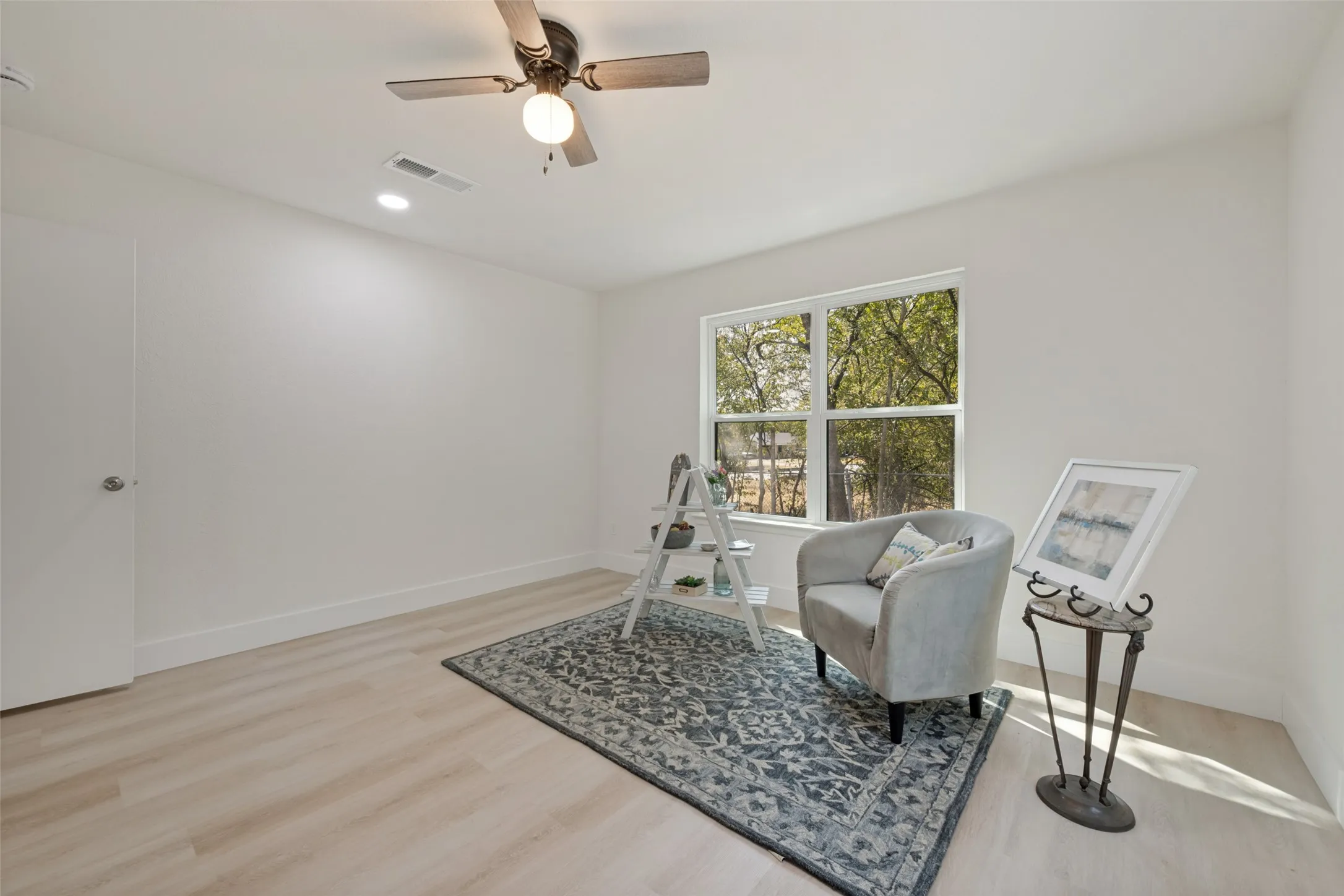 Recessed lighting, wood-finish flooring, ceiling fan, and a window with outdoor scenery