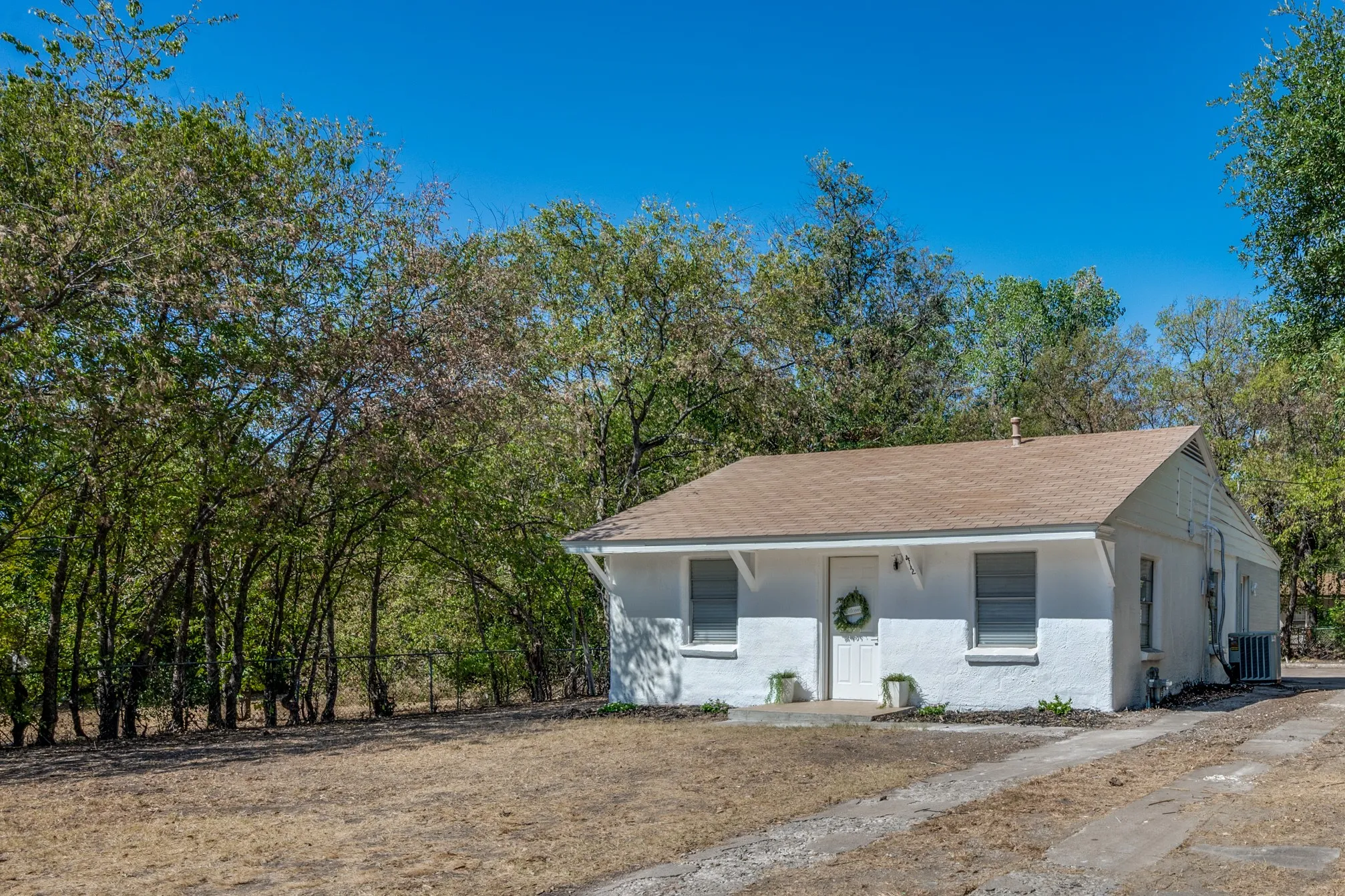 White exterior finish and a brown shingle roof