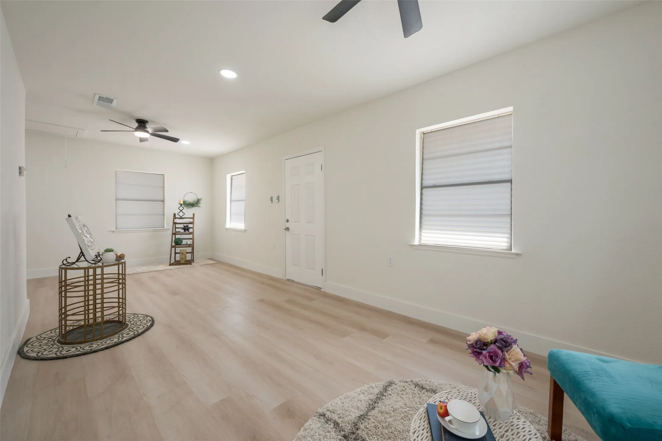 Light-toned wood-finish flooring, recessed lighting, and dual ceiling fans