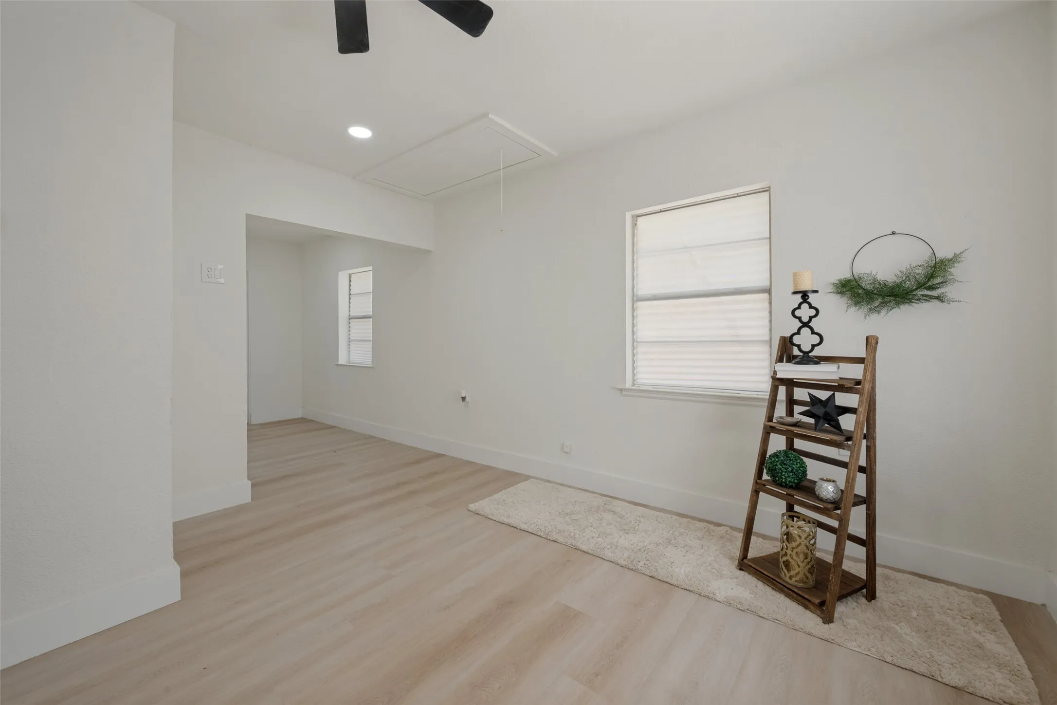 Recessed lighting, wood-finish flooring, white walls, and a ceiling fan
