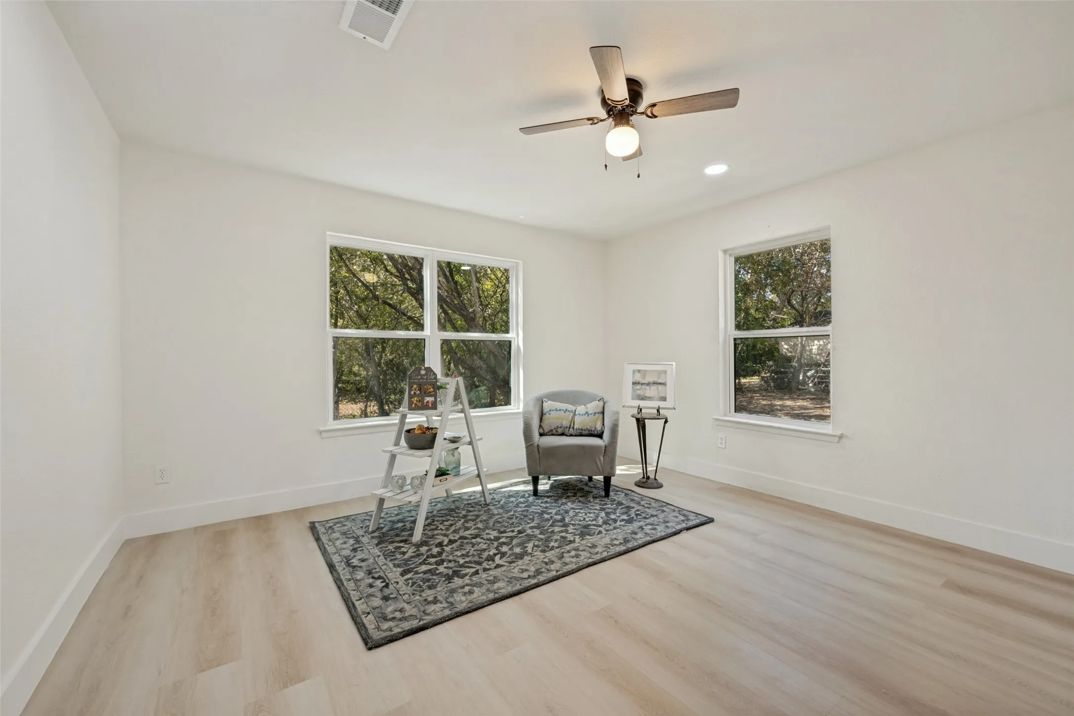 Recessed ceiling lighting, wood-finish flooring, and white walls