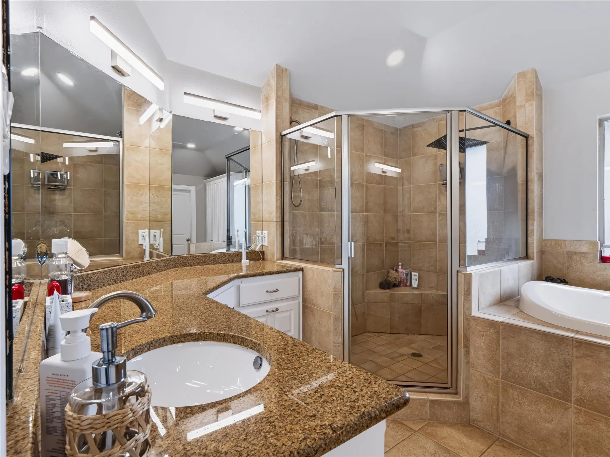 Dual vanity with granite-style countertop, undermount sinks, and chrome fixtures