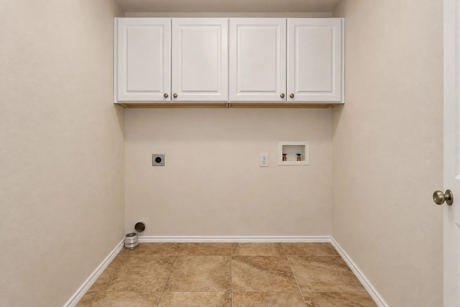 Laundry area featuring white cabinetry, tile flooring, and light-colored walls