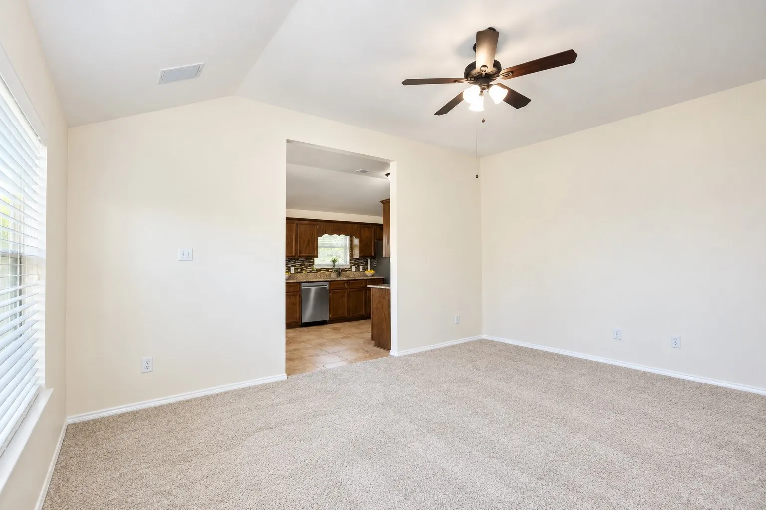 Vaulted ceiling with a pendant light fixture, light neutral wall paint, and dark wood-finish flooring