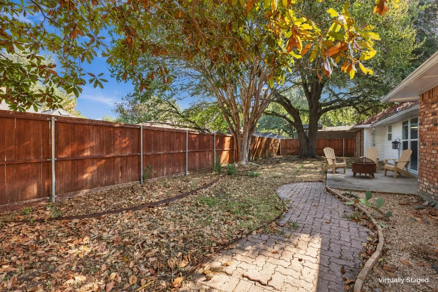 Paved brick pathway leading to a concrete patio
