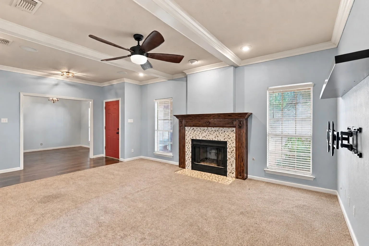 Living space featuring a fireplace with a wood mantle and tile surround, recessed lighting, and a ceiling fan