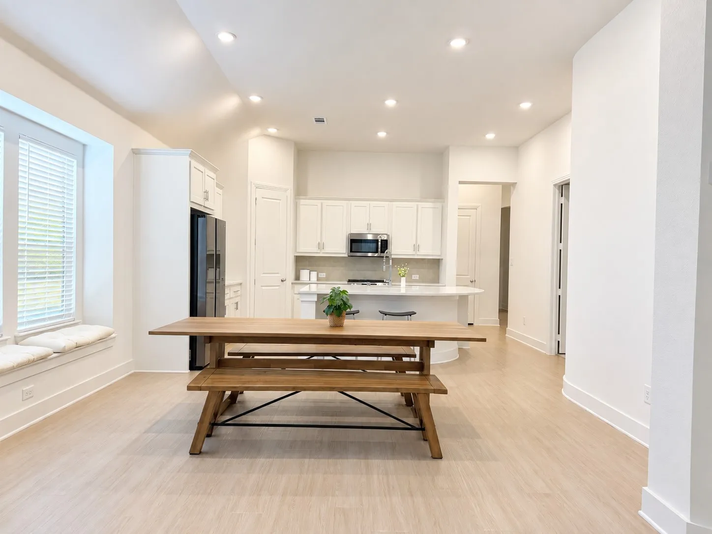 Open-concept living space featuring light wood-finish flooring, recessed lighting, and a window seat