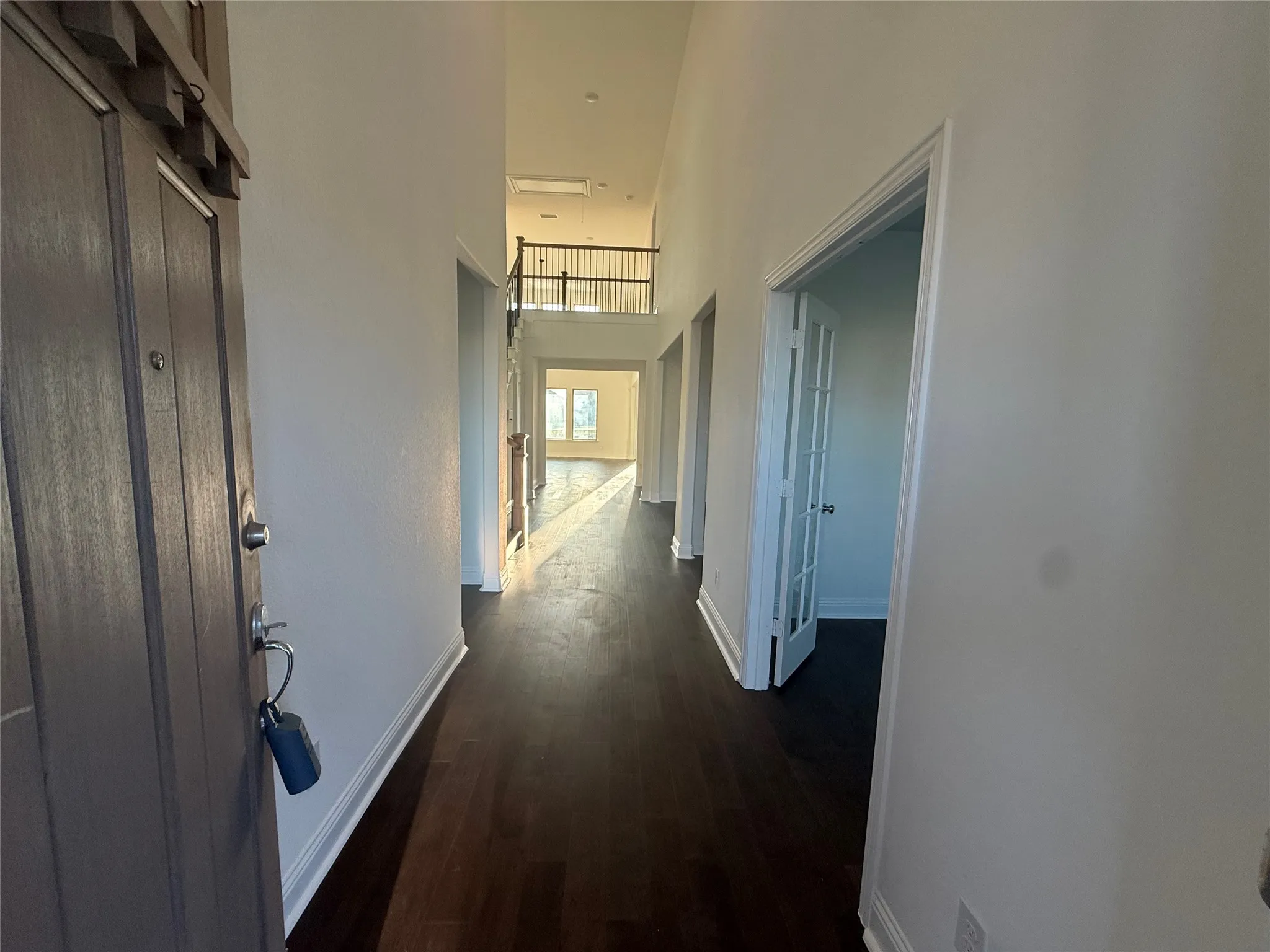 Grand entry foyer with wood-finish flooring, tall ceilings, and a second-story balcony