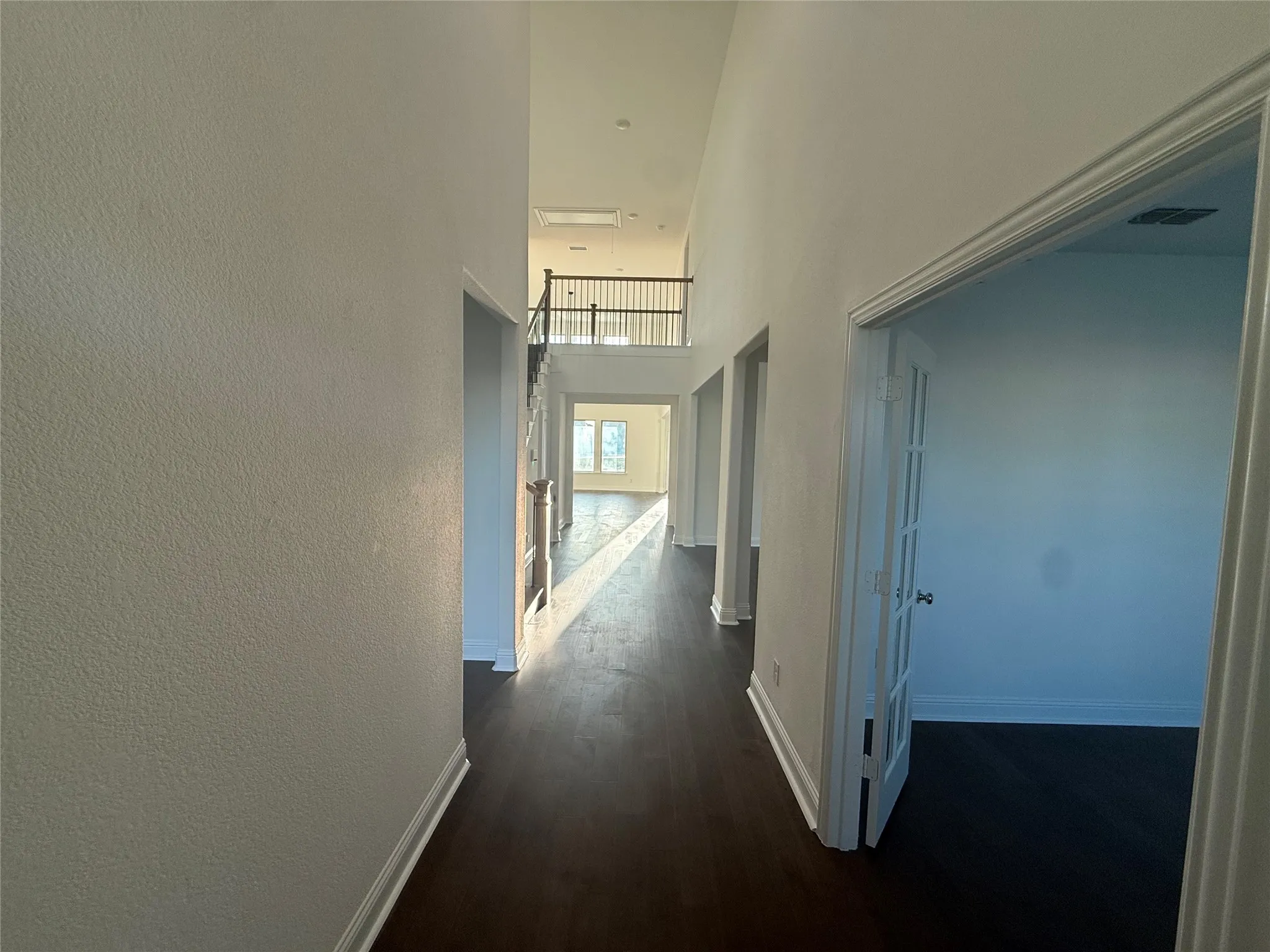 Hallway featuring wood-finish flooring, white walls, and a white trim package