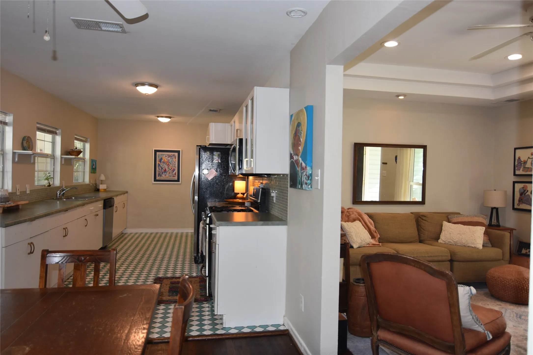 Kitchen featuring a checkered floor pattern, white cabinetry, and stainless steel appliances