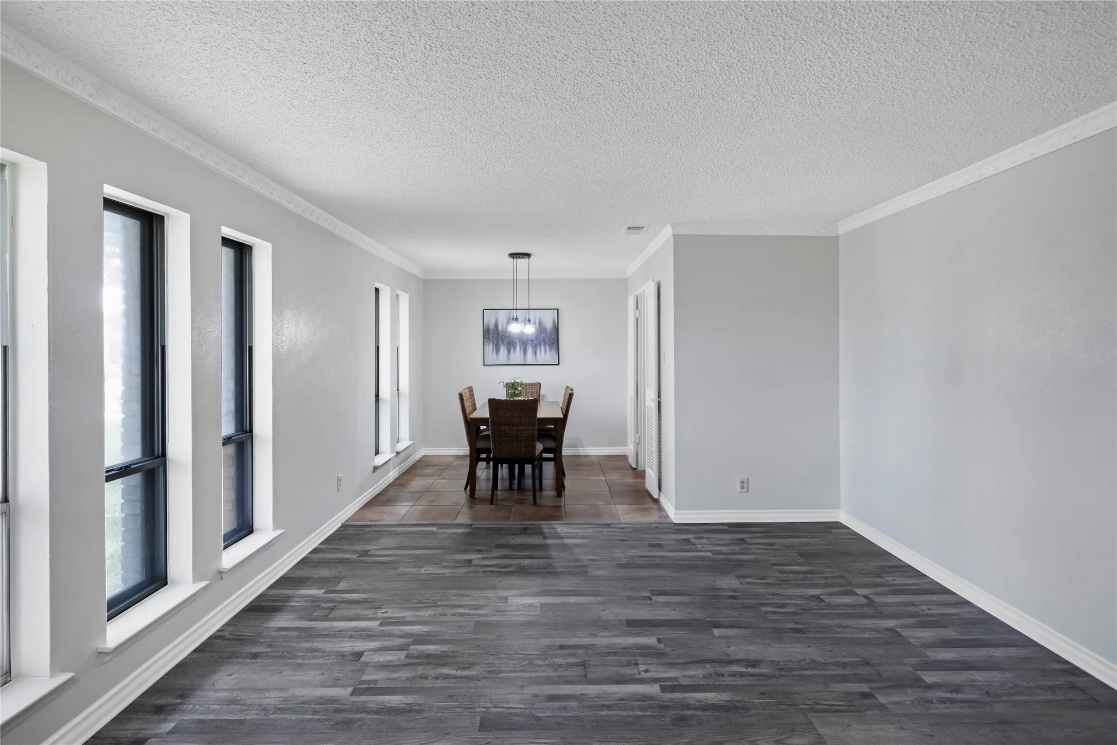 Wood-finish flooring with a multi-pane window wall and crown molding