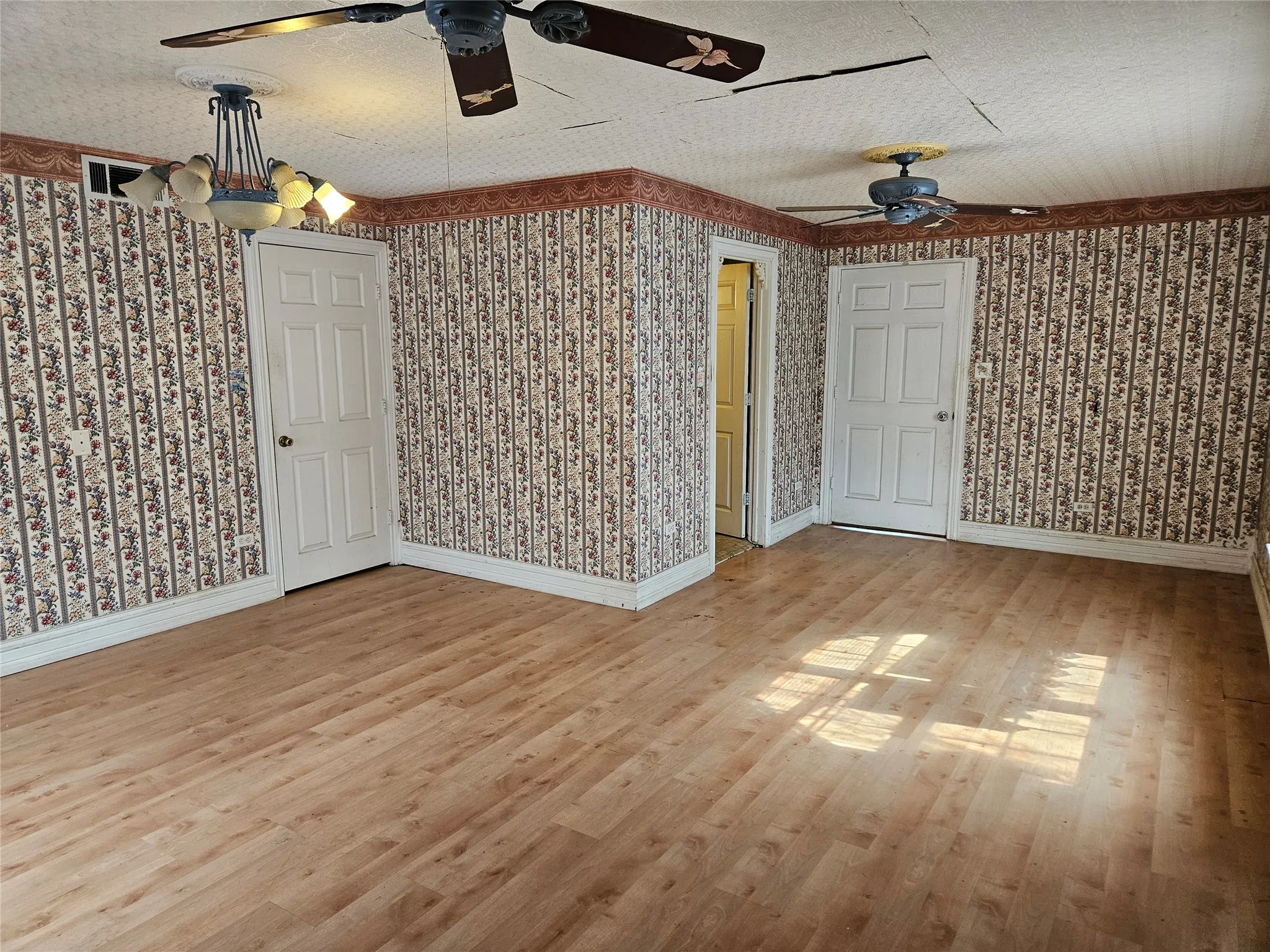 Unfurnished room featuring ceiling fan, light wood-style flooring, and a textured ceiling