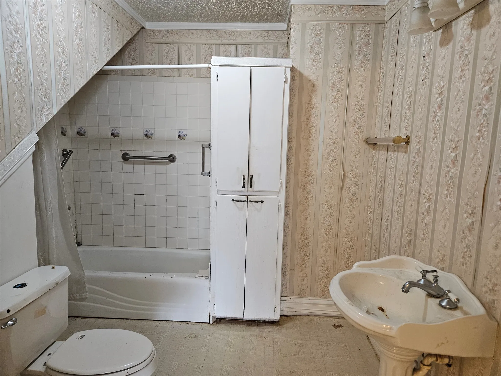 Bathroom featuring light flooring, shower / bath combo, and ornamental molding