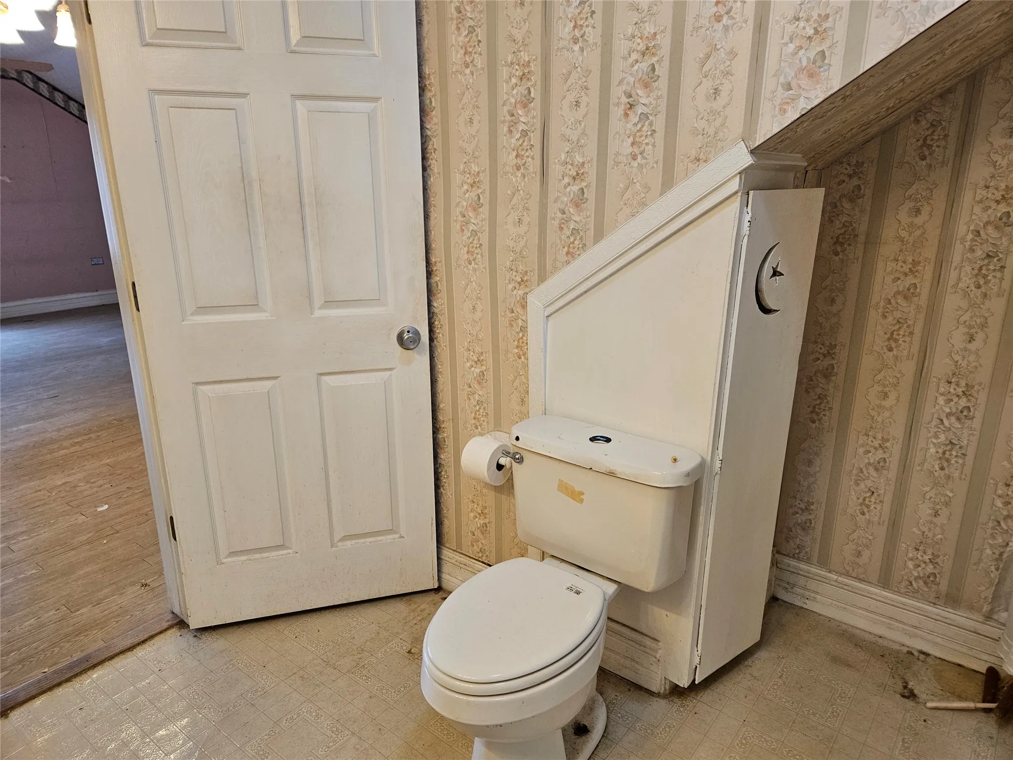 Bathroom with light floors and wallpapered walls