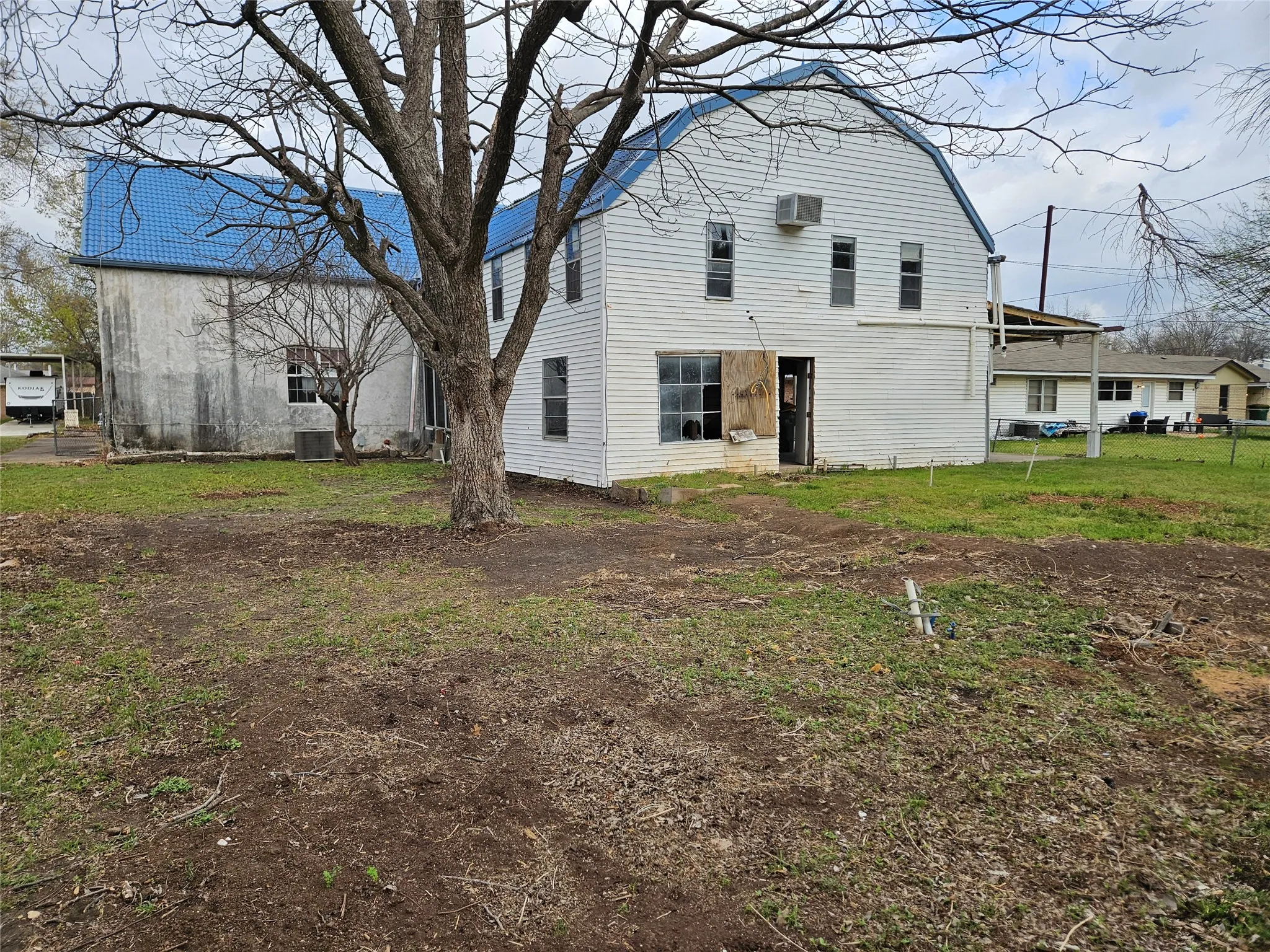 Rear view of property with a gambrel roof and a lawn