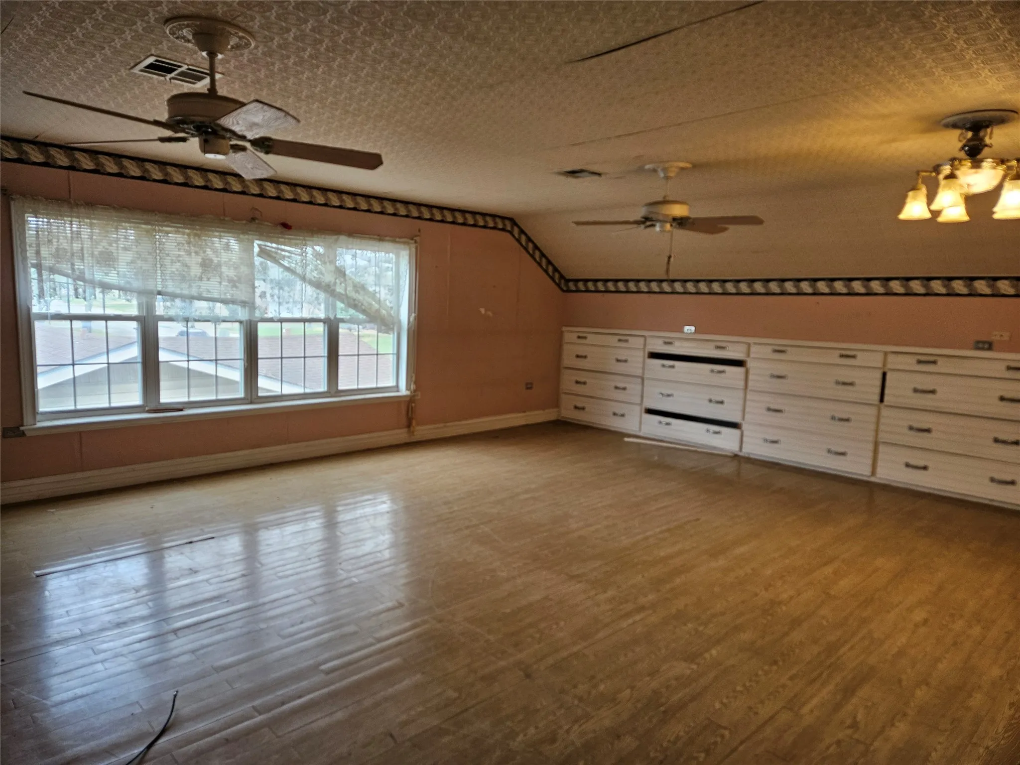 Additional living space featuring ceiling fan, wood finished floors, and vaulted ceiling