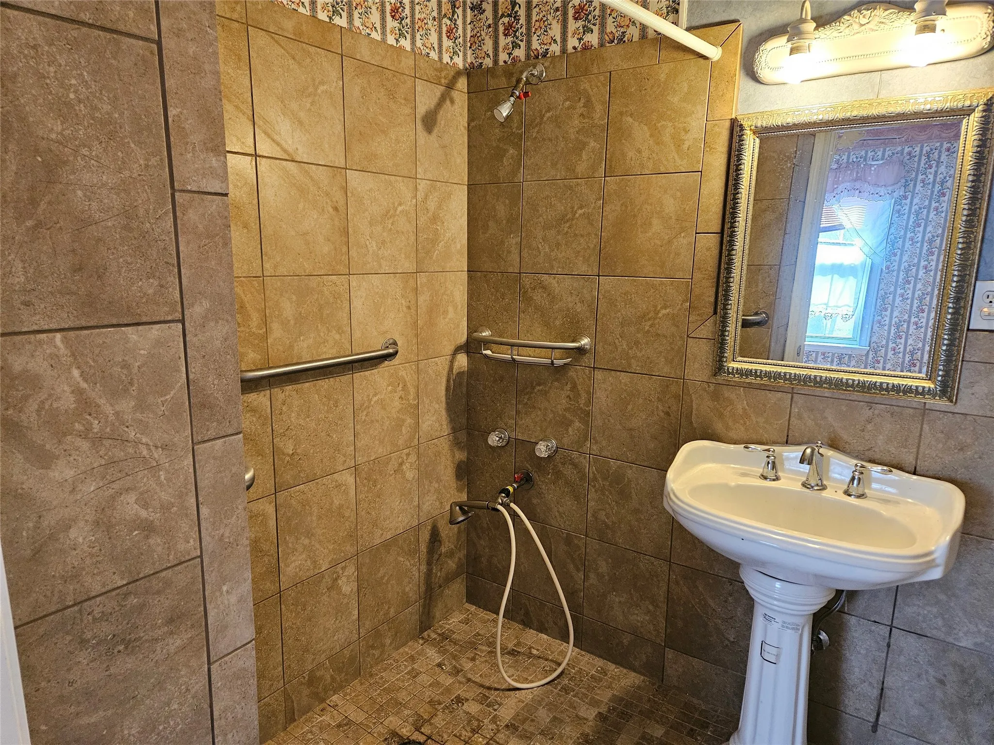 Bathroom with a tile shower and tile walls