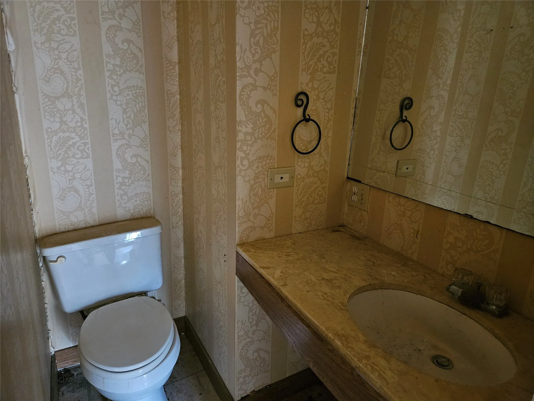 Bathroom featuring wallpapered walls and vanity
