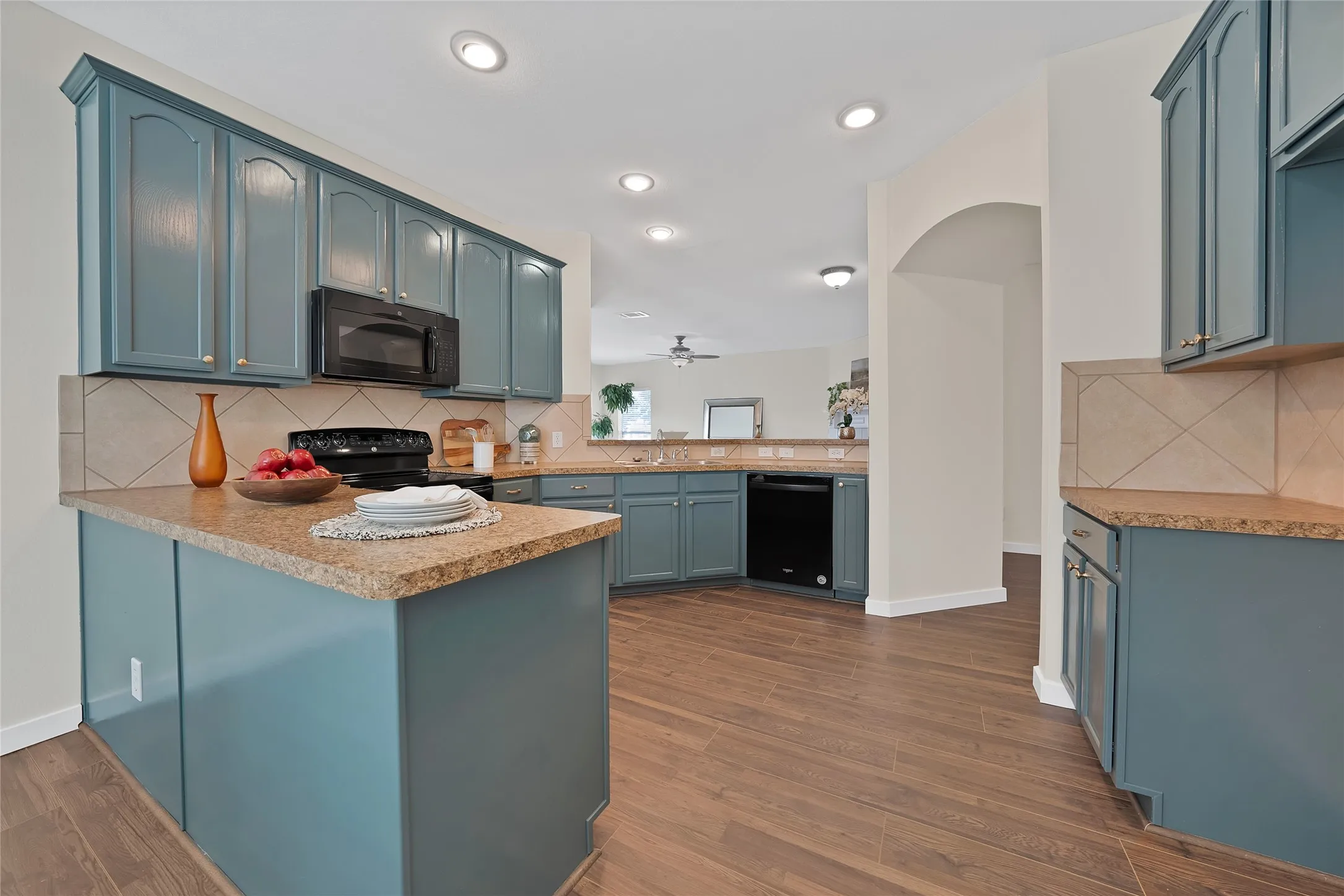 Kitchen featuring wood-finish flooring, recessed lighting, and a tile backsplash