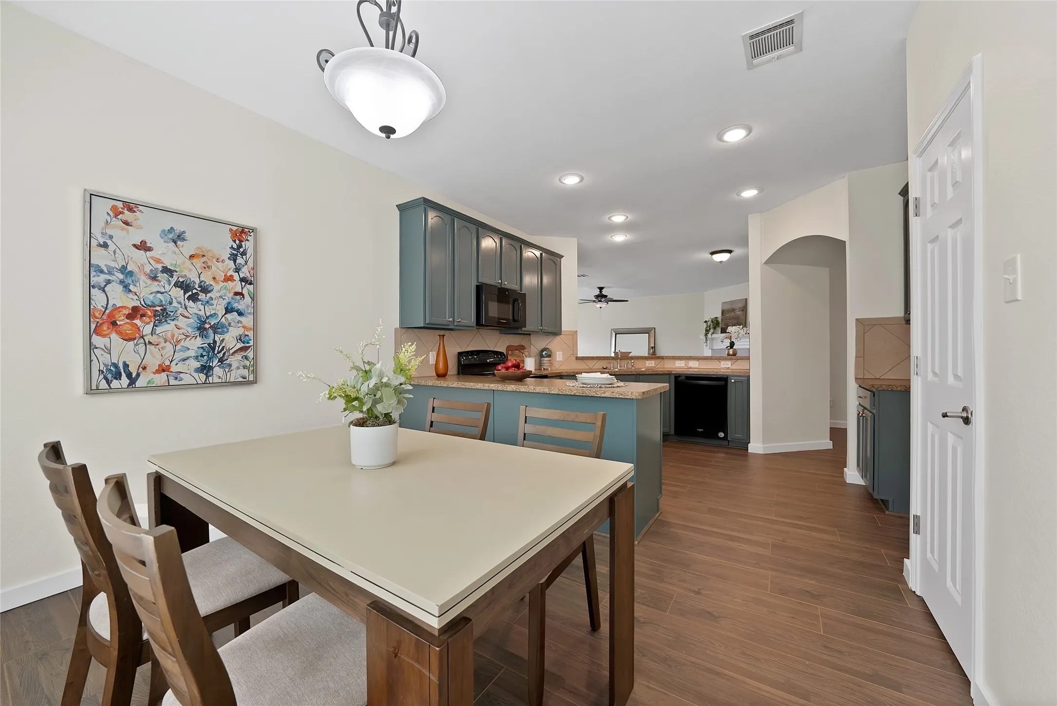 Kitchen featuring wood-finish flooring, recessed lighting, and a kitchen island with seating