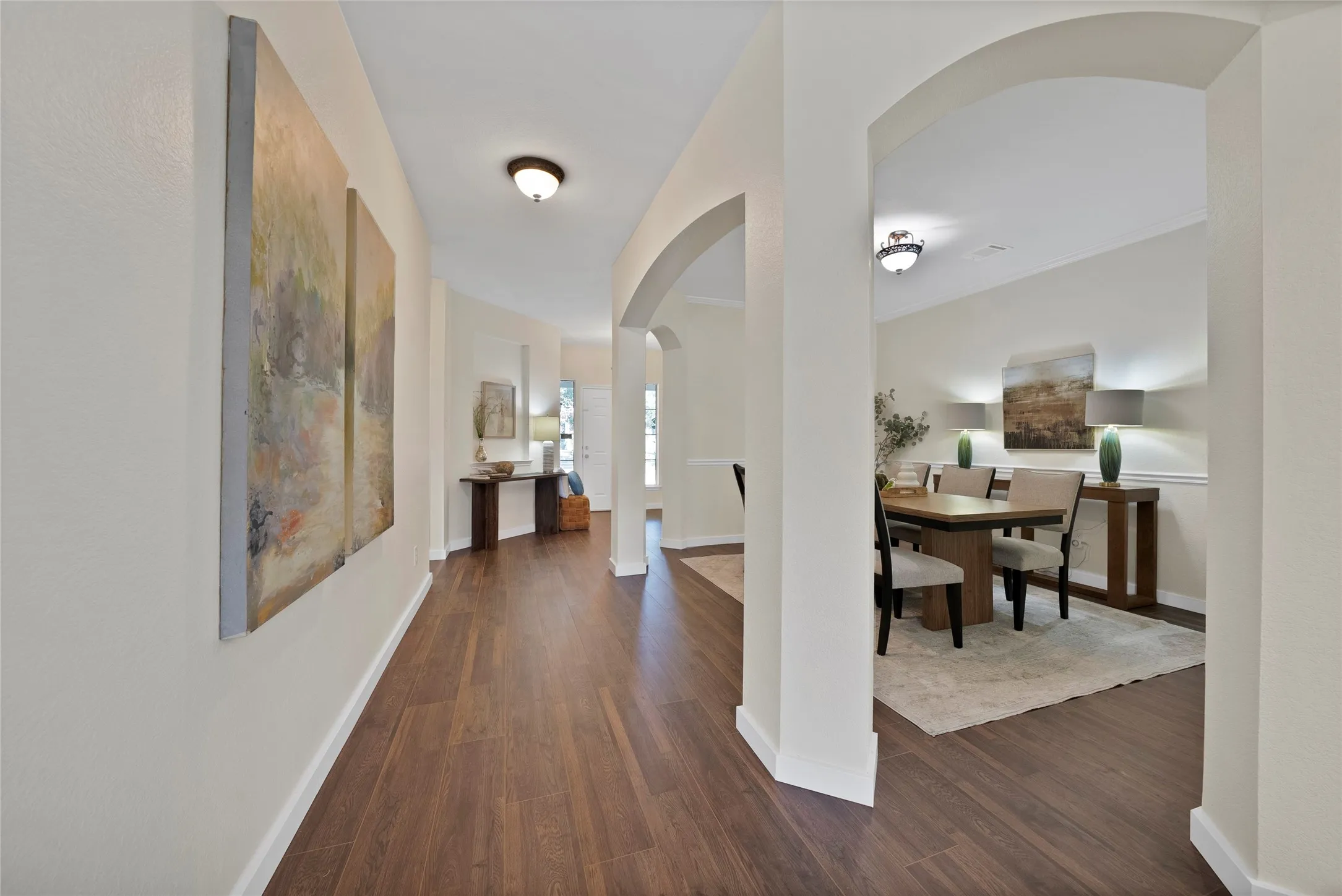 Hardwood-finish flooring, arched doorways, recessed lighting, and crown molding