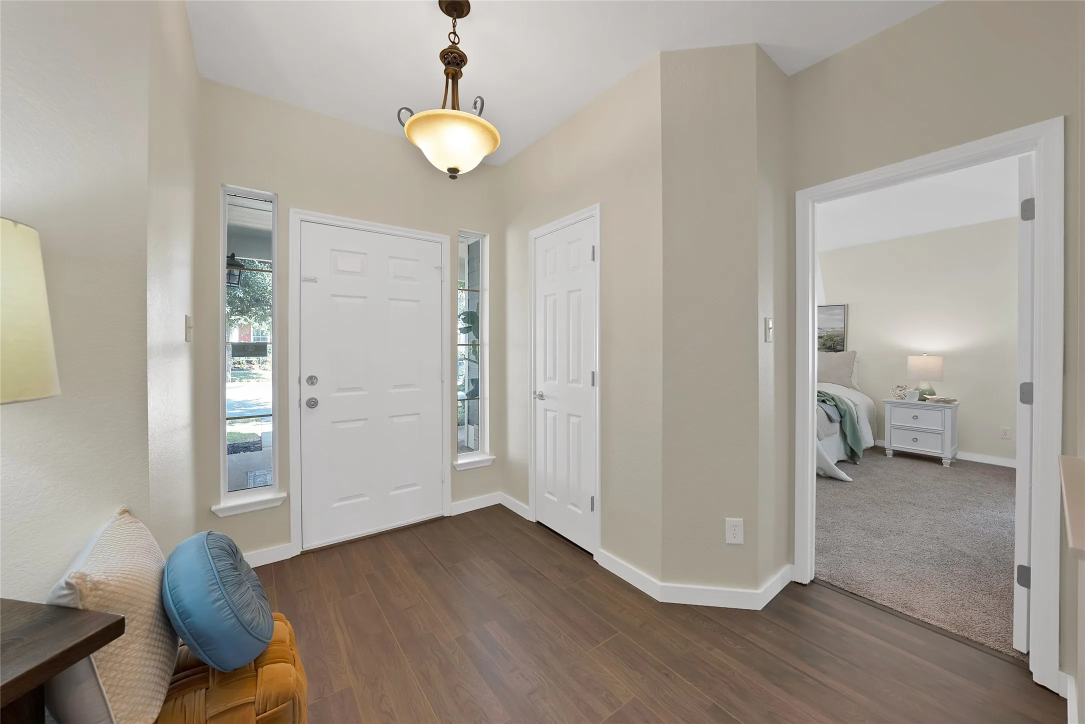 Entryway featuring wood-finish flooring, a paneled entry door with sidelights, and an overhead decorative light fixture
