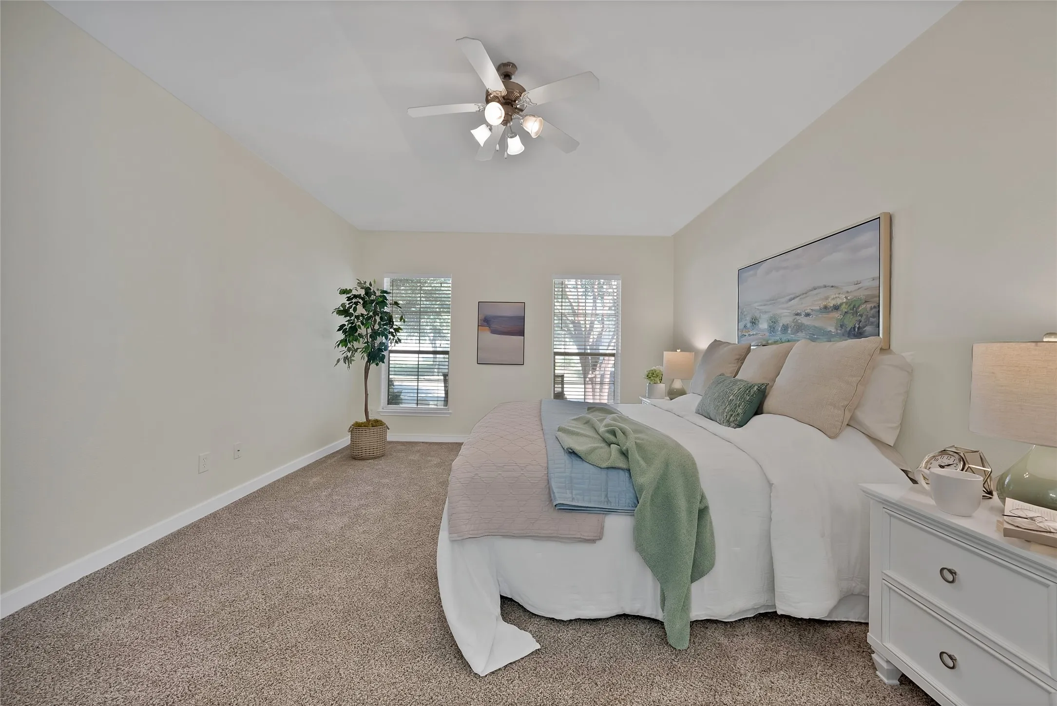 Vaulted ceiling with a ceiling fan, dual windows, and plush carpeting