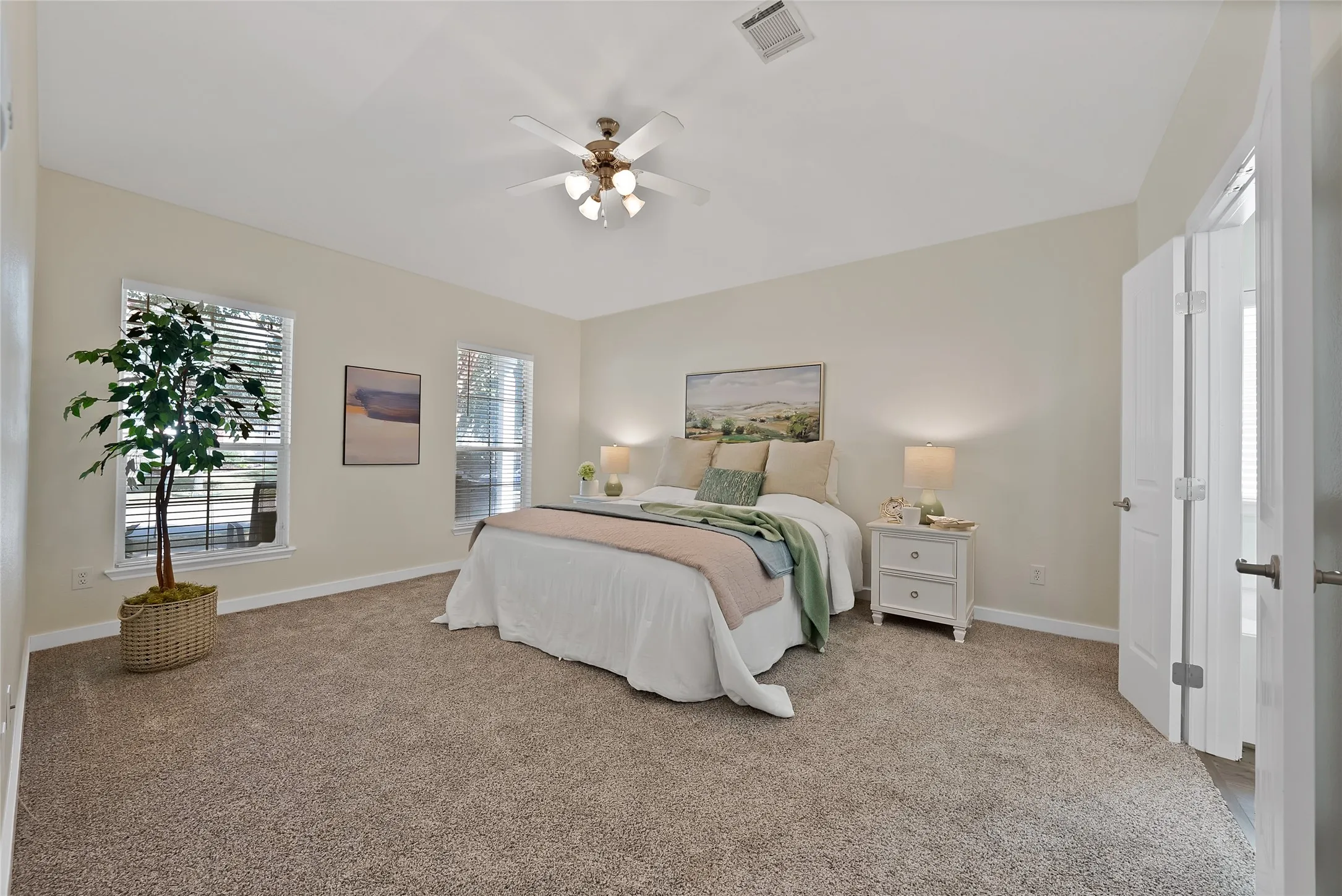 Carpeted bedroom featuring multiple windows with blinds, a ceiling fan with integrated lighting, and a neutral color palette