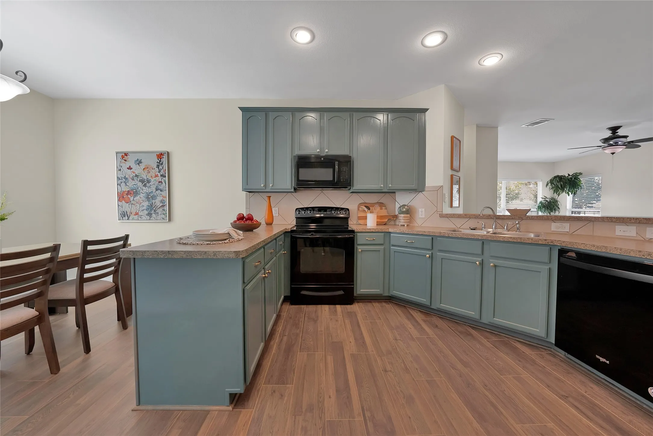 Kitchen featuring wood-finish flooring, recessed lighting, and blue-painted cabinetry