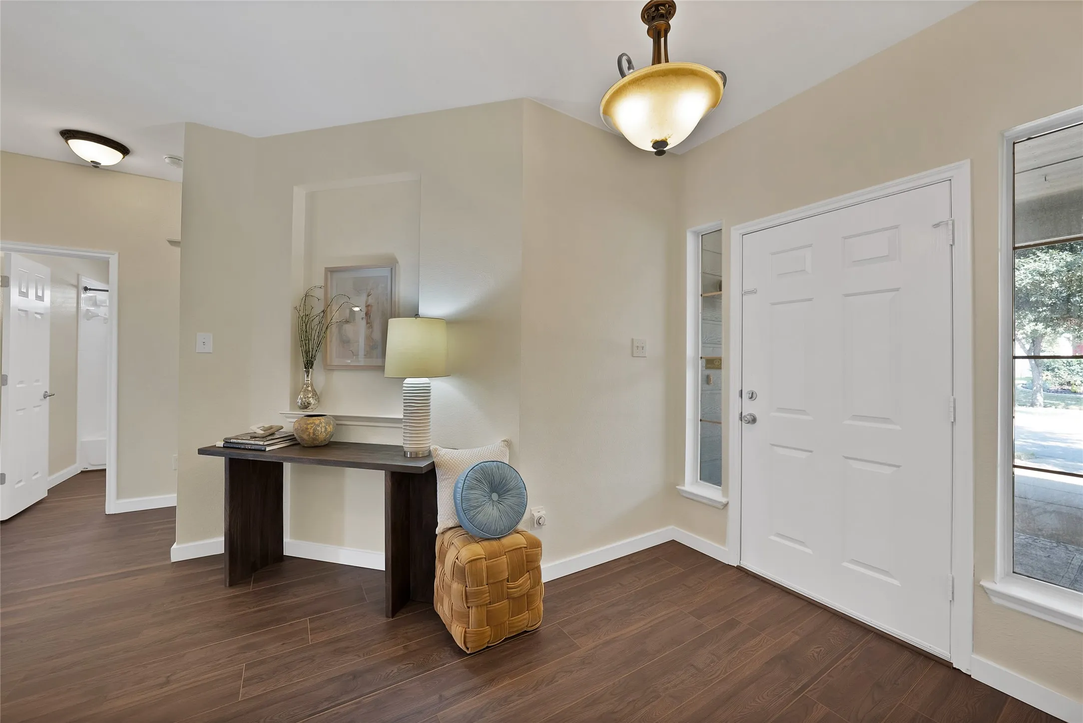 Entryway featuring wood-finish flooring, a paneled door, and two side-light windows