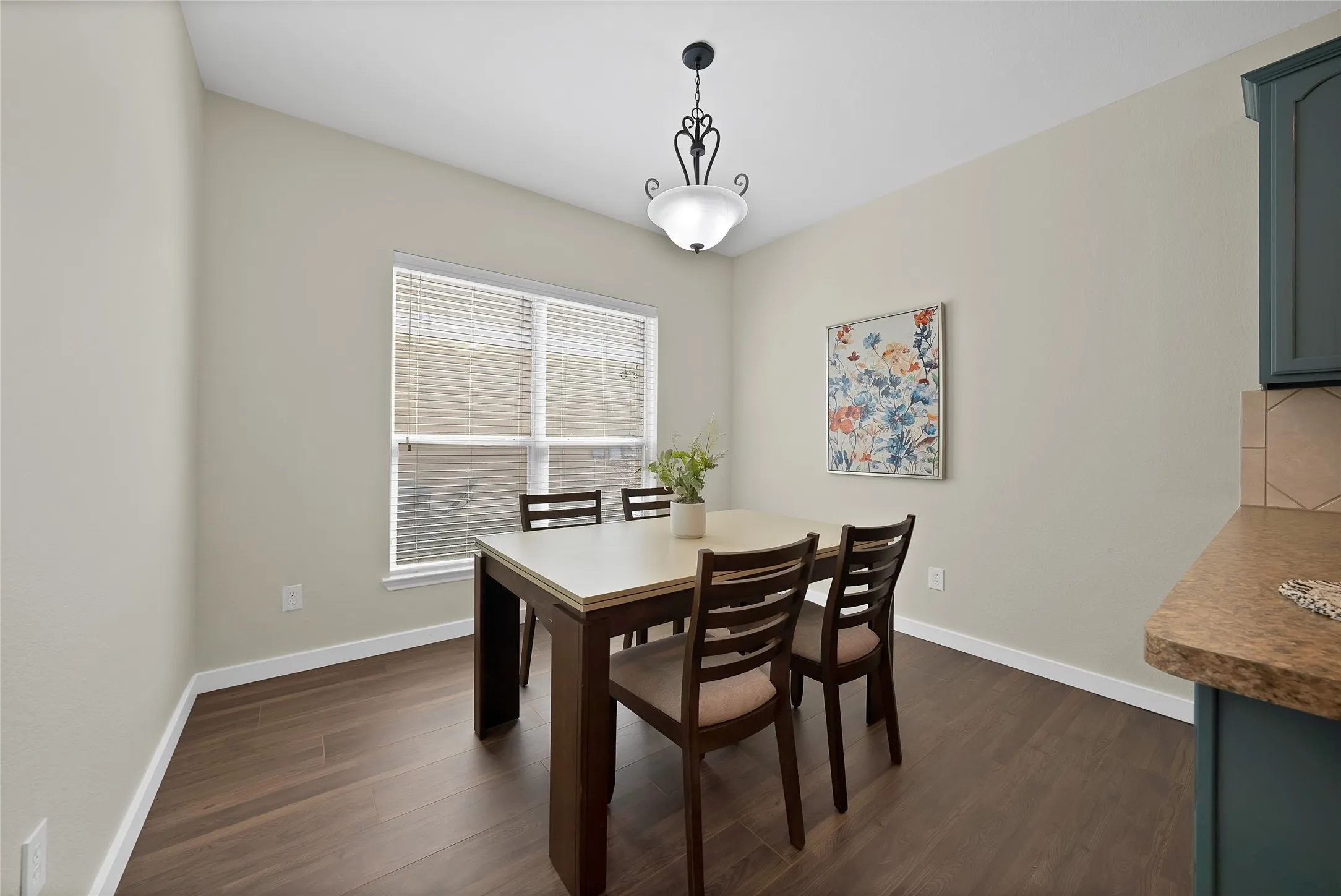 Wood-finish flooring with a broad window, overhead lighting fixture, and light-toned walls