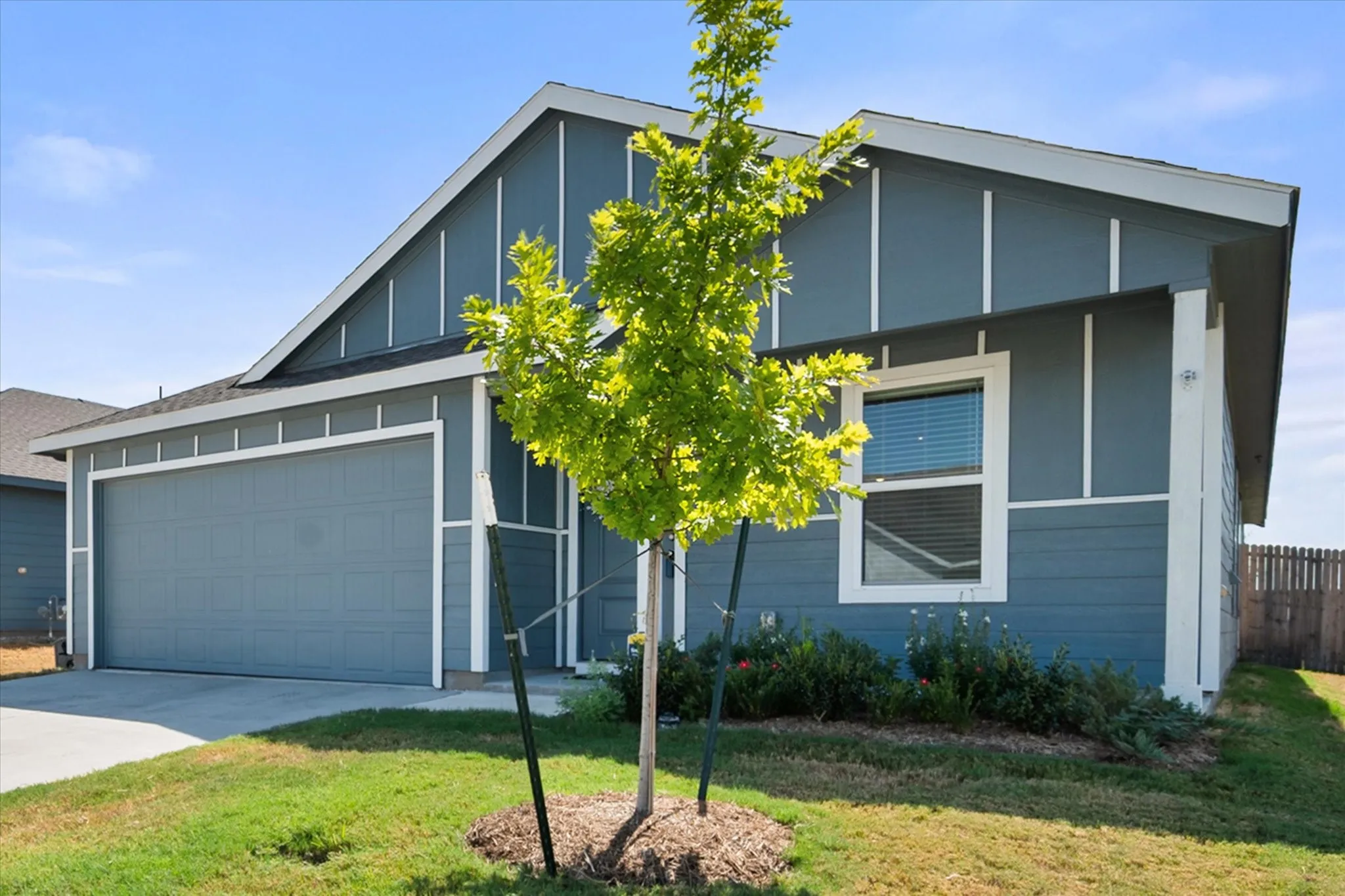 Contemporary exterior with board and batten siding, attached garage, and a single window with white trim