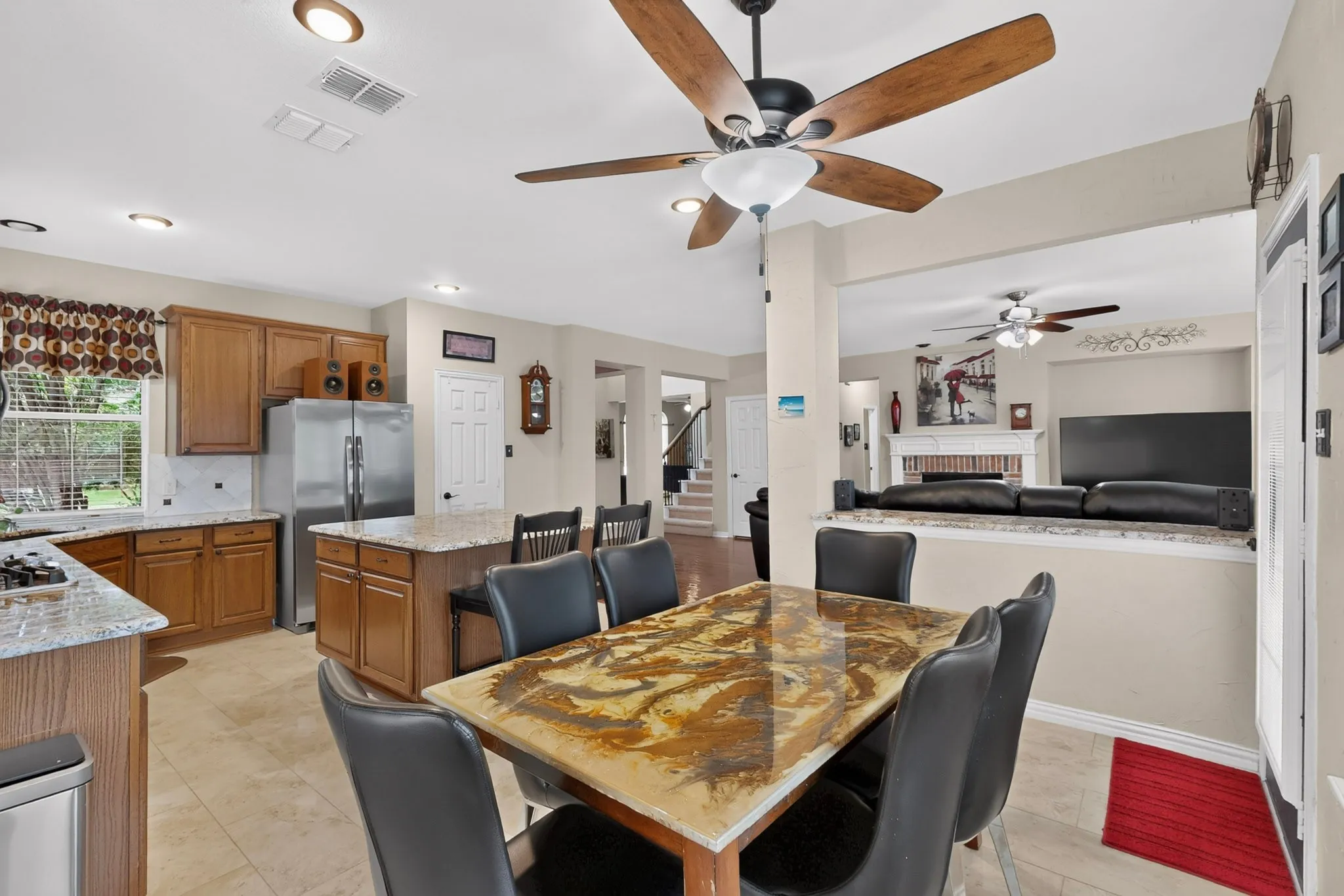Kitchen with wood cabinetry, light-toned countertops, and stainless steel refrigerator