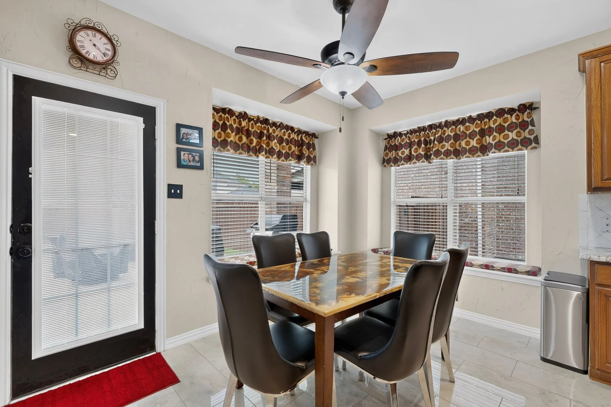 Ceramic tile flooring, multiple windows with blinds, a ceiling fan, and a light-colored wall finish
