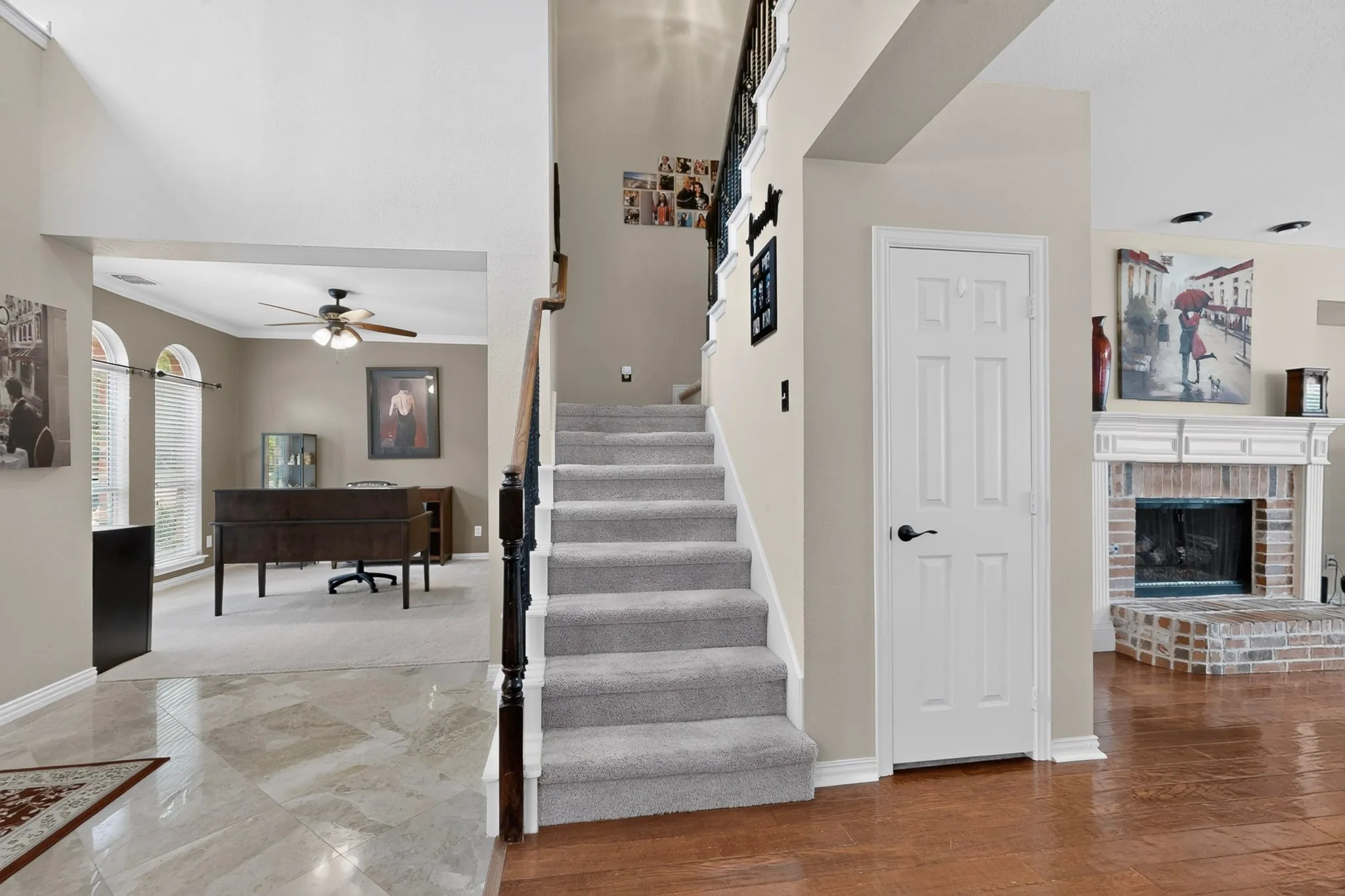 Grand foyer with high ceilings, plush carpeted staircase, and wood-finish flooring