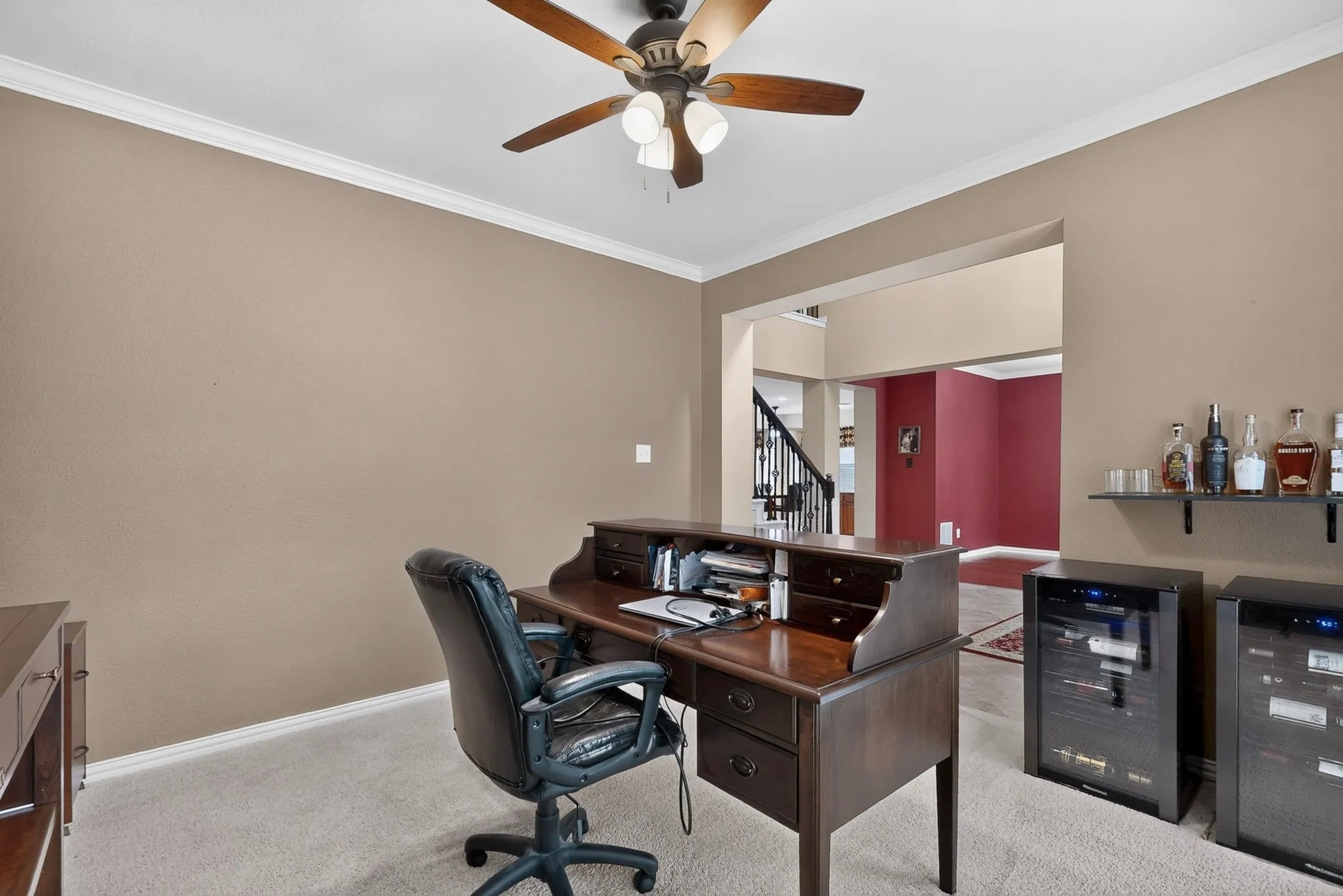 Carpeted flooring with crown molding and a ceiling fan with integrated lighting