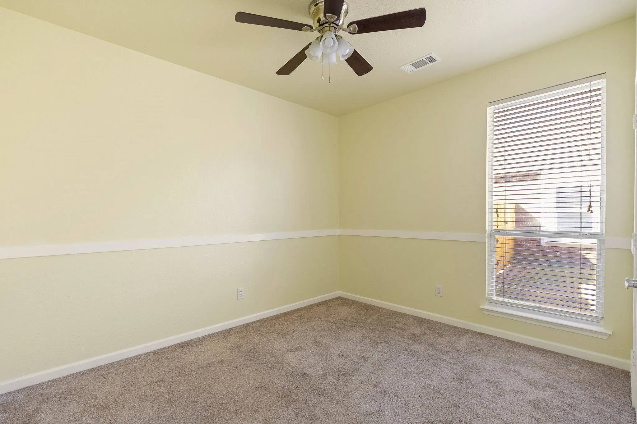 Carpeted flooring, ceiling fan with light fixture, window with blinds, and decorative wall molding