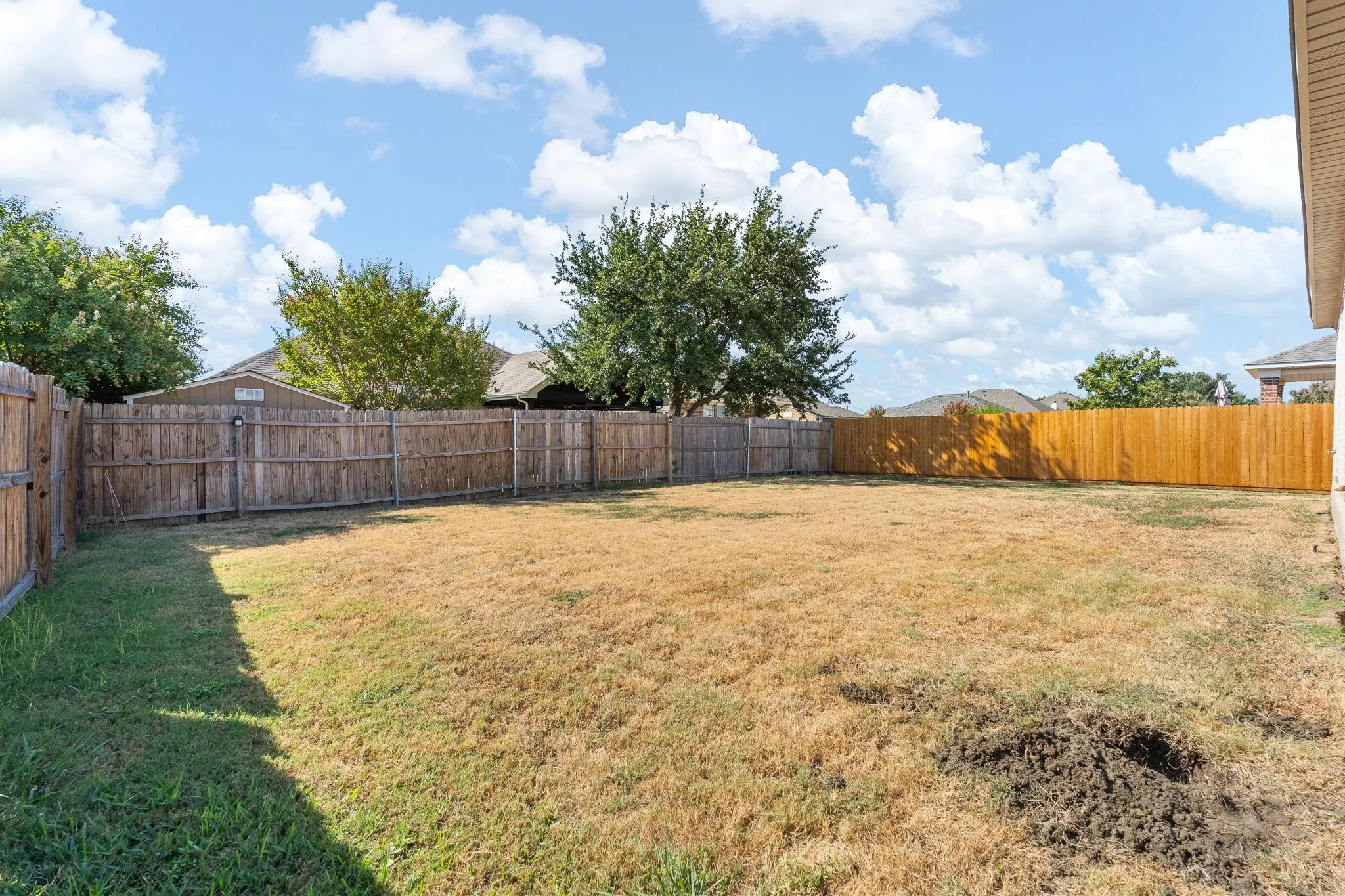 Expansive backyard area enclosed by wood fencing