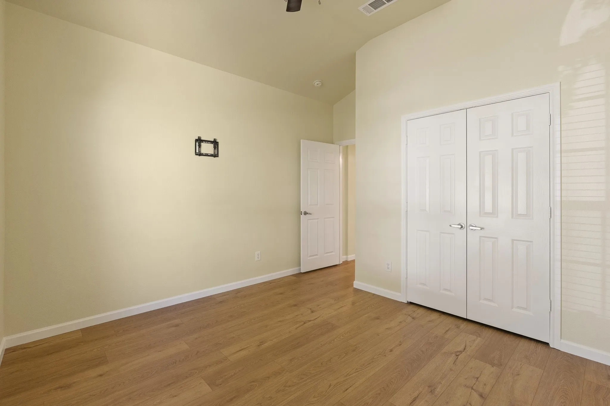 Wood-finish flooring, vaulted ceiling, and bi-fold closet doors
