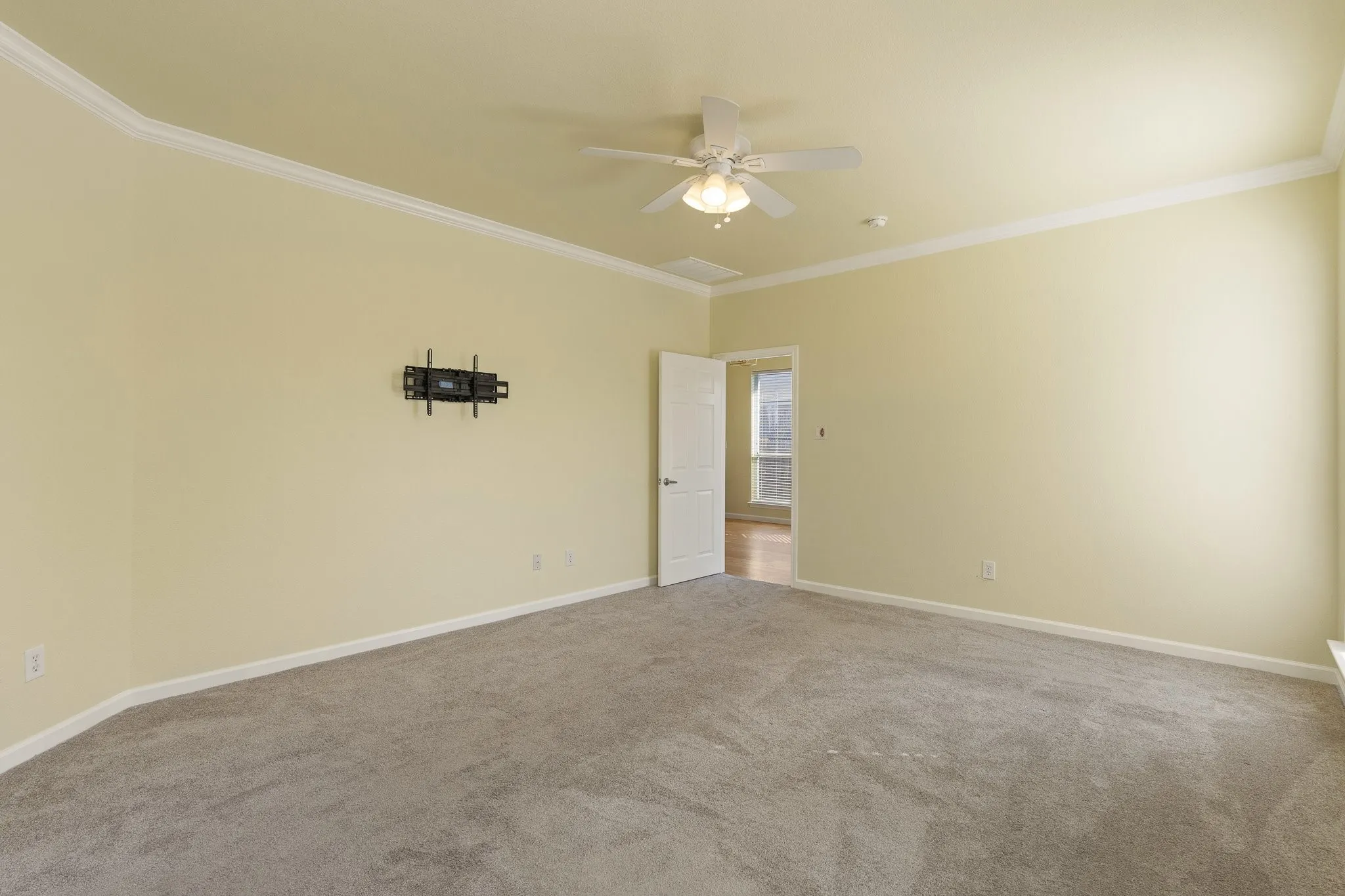 Neutral-toned carpeting with light-colored walls and white crown molding