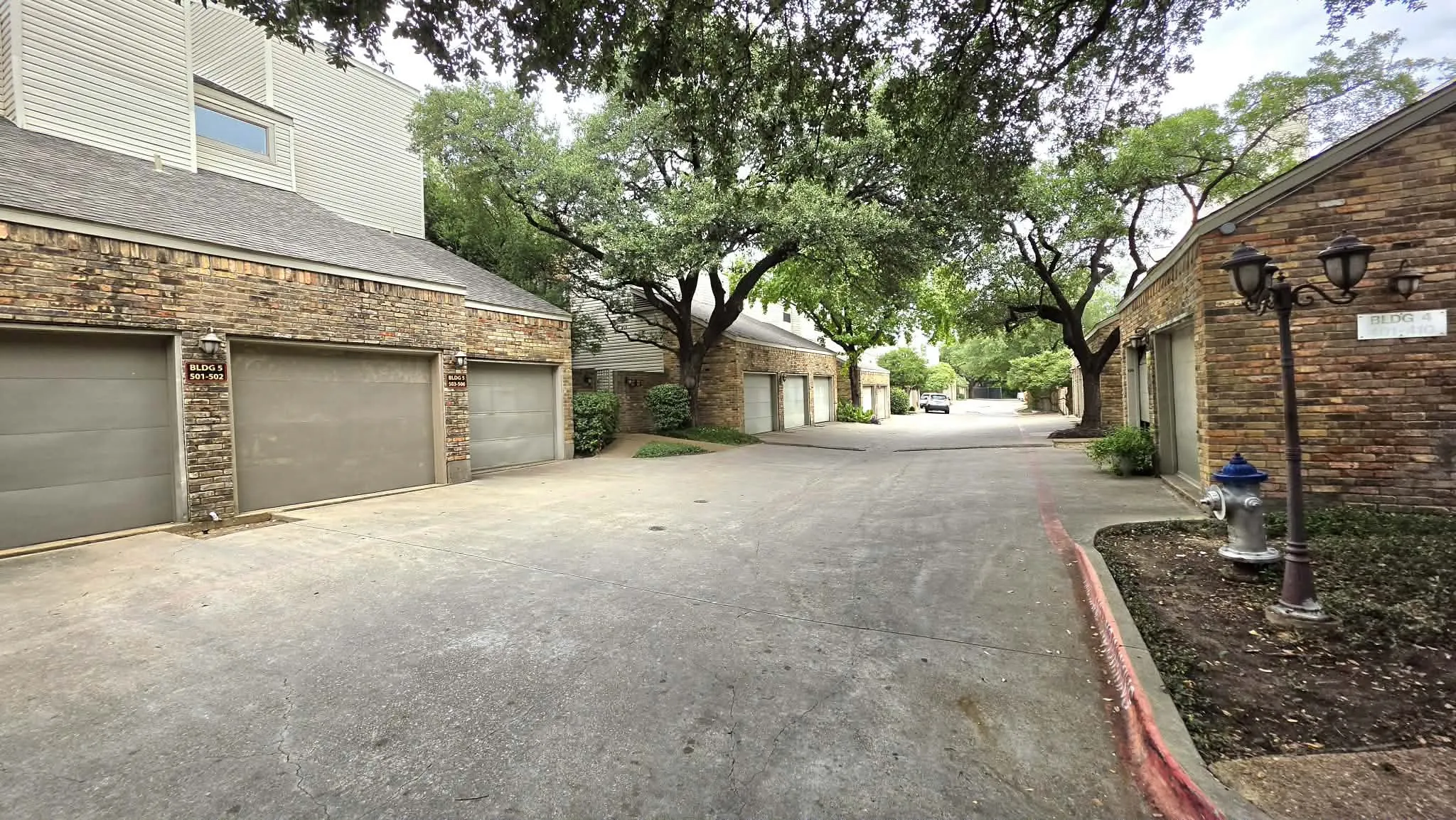 Brick exterior ,mature trees, and concrete paved areas