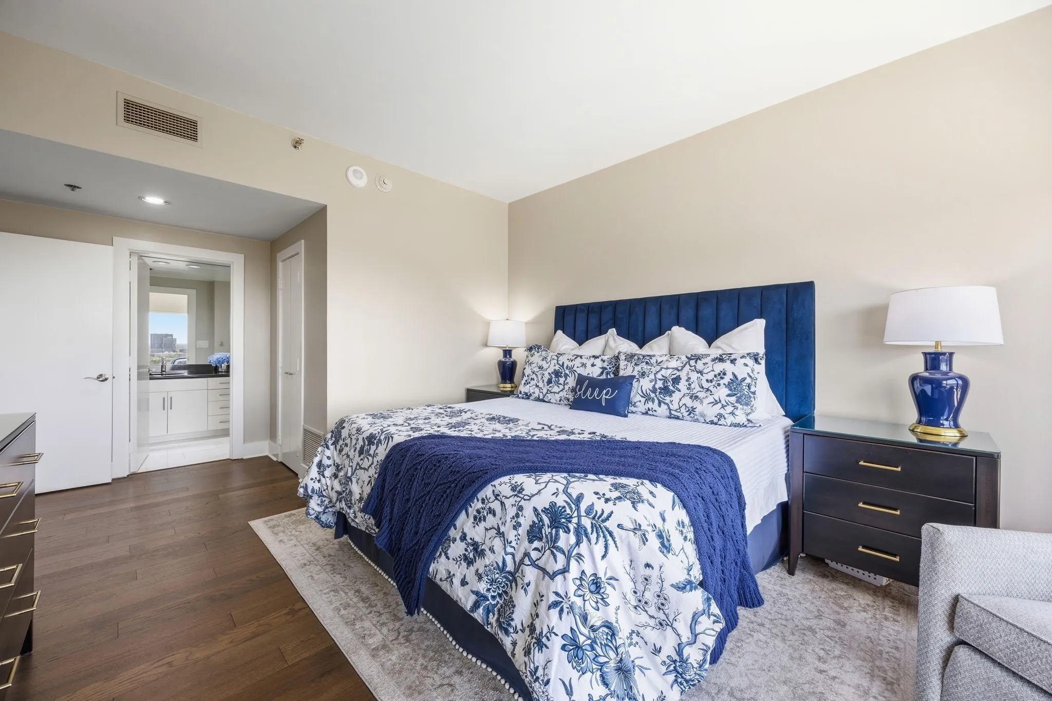 This view of the spacious primary bedroom highlights the entrance to the beautifully updated ensuite bathroom.