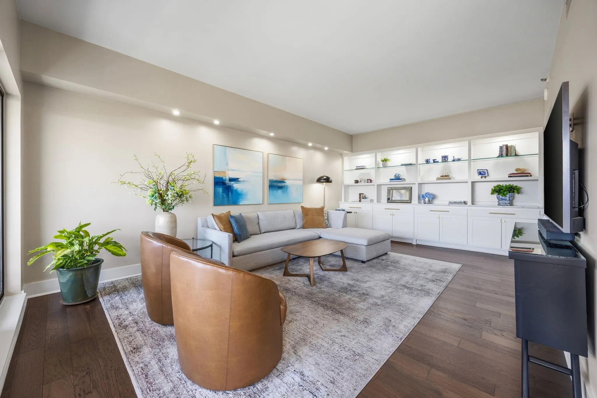 Thoughtfully placed accent lighting highlights your art collection, while the wall of custom built-ins offers additional display space, decorative possibilities, and convenient storage.