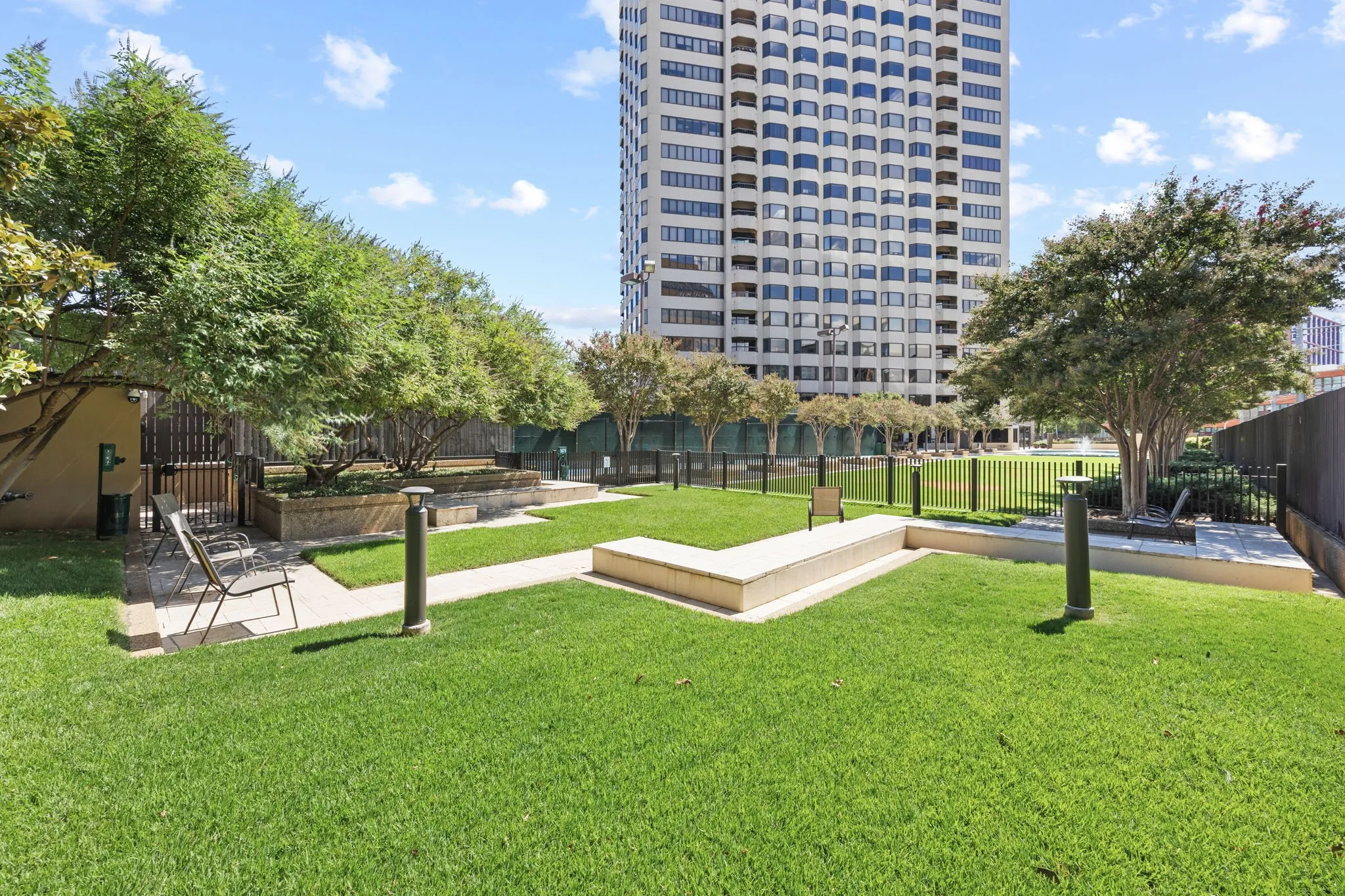 An expansive, beautifully landscaped garden area features a tranquil water feature, a separately fenced pet park, and manicured green space—offering residents a peaceful setting to relax, stroll, or enjoy the outdoors.