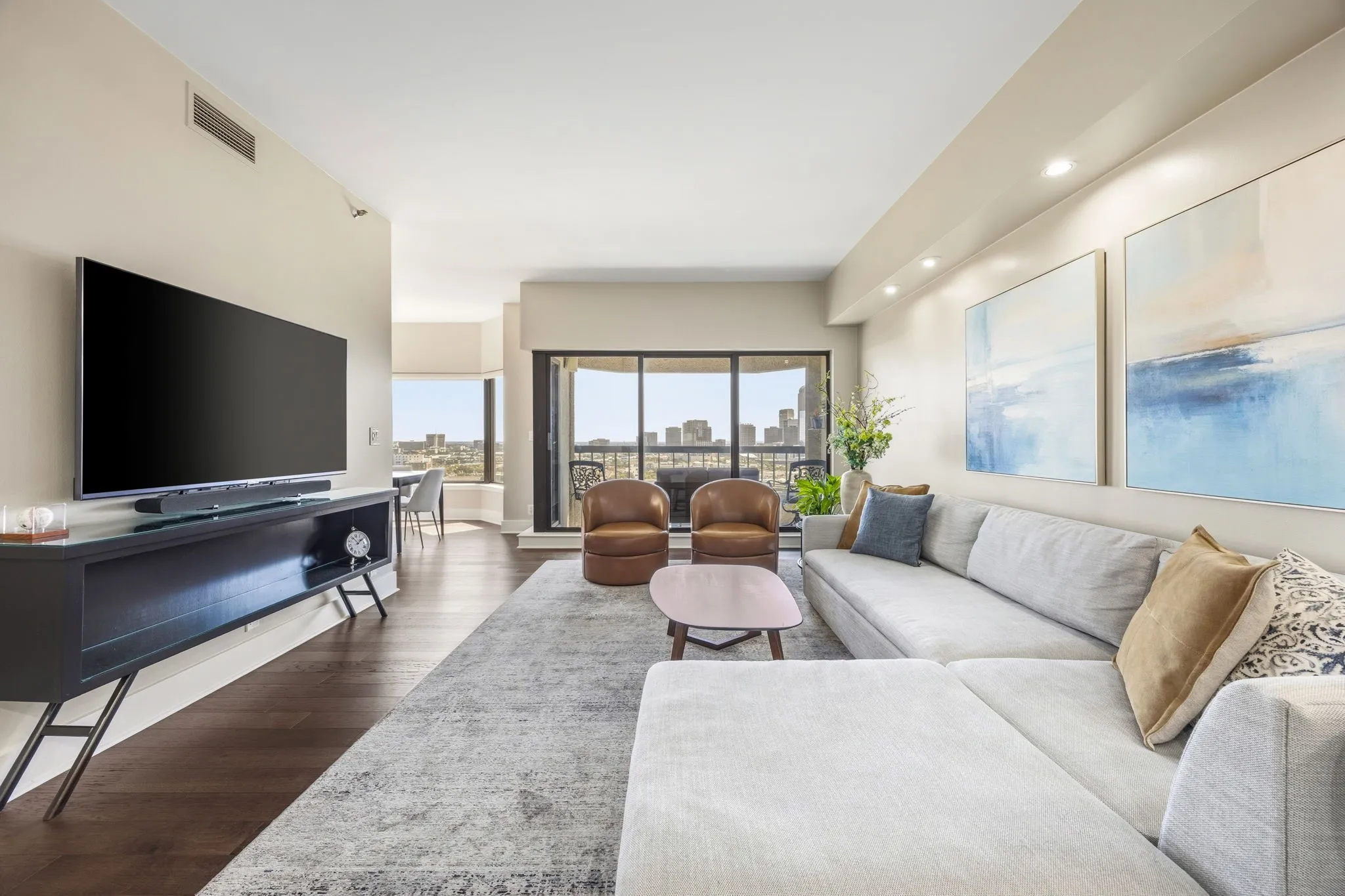 The inviting living area is bathed in natural light from the expansive sliding glass doors that open to the private balcony, creating a bright and airy space perfect for relaxing or entertaining.