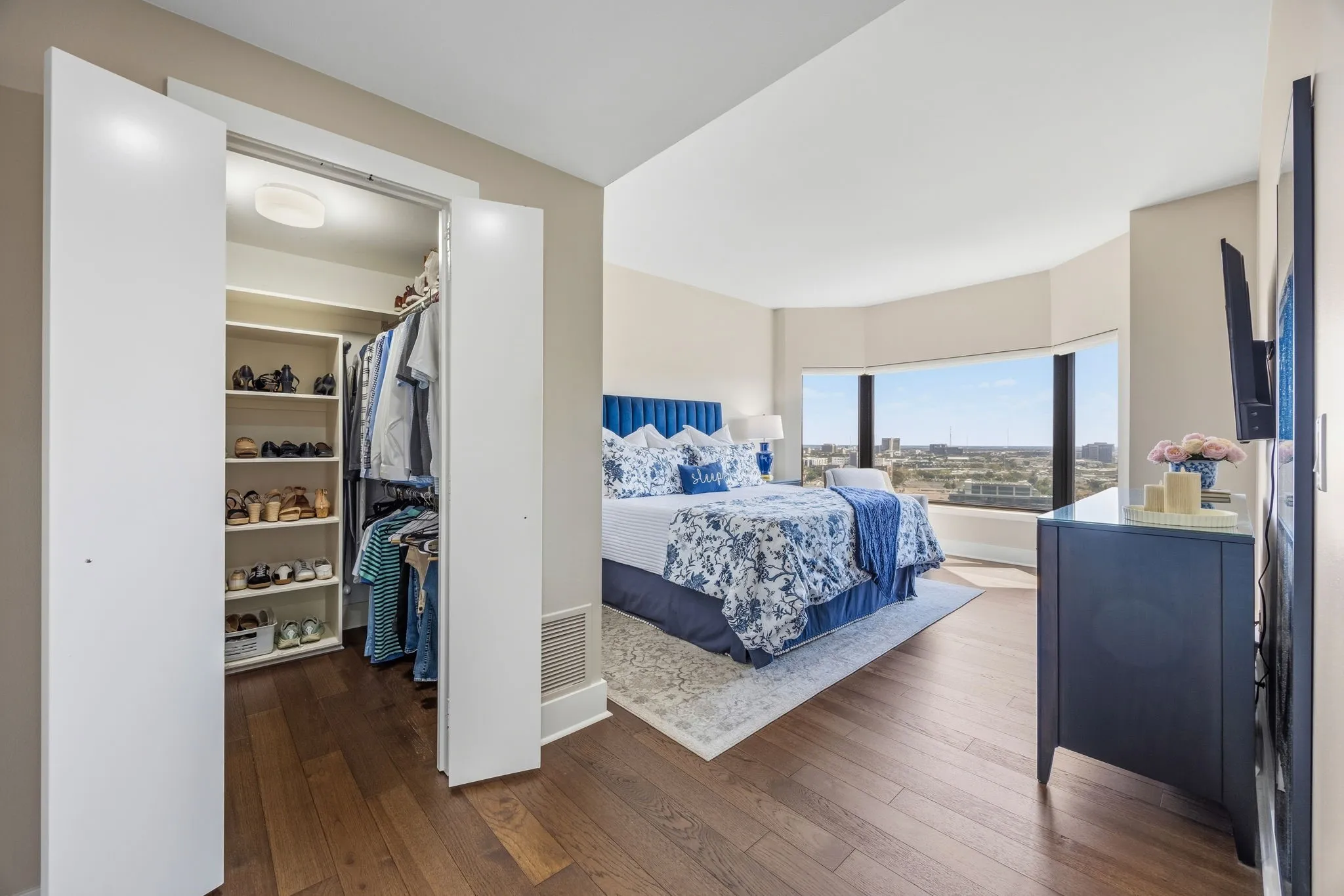 The generously sized primary bedroom features a custom-designed walk-in closet, while rich engineered wood flooring adds a stylish contrast to the light-filled space. A large bay window welcomes abundant natural light and creates a warm, inviting atmosphere.