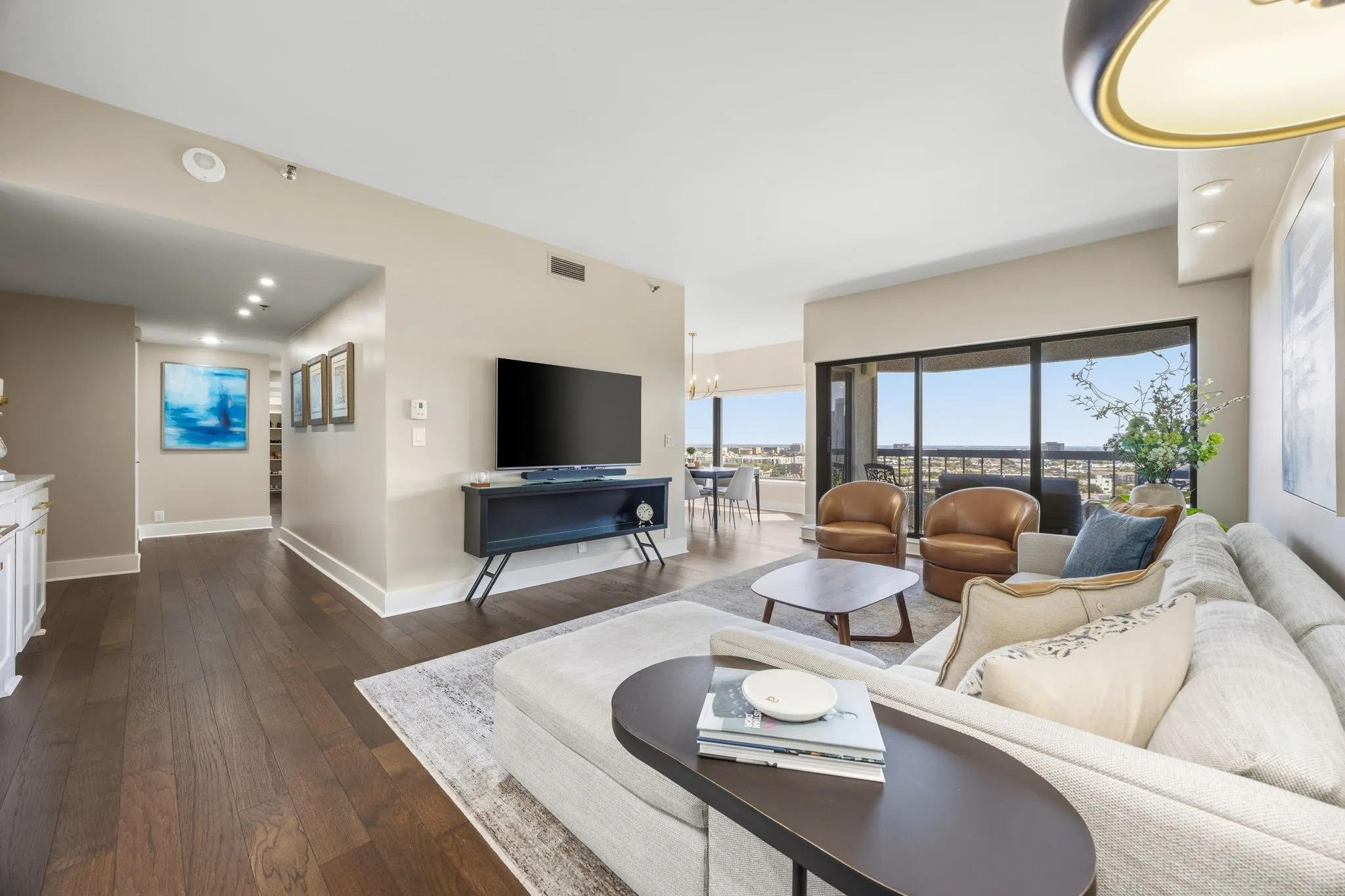 A wider view of the spacious living area showcases the welcoming entry foyer and seamless access to the private balcony.