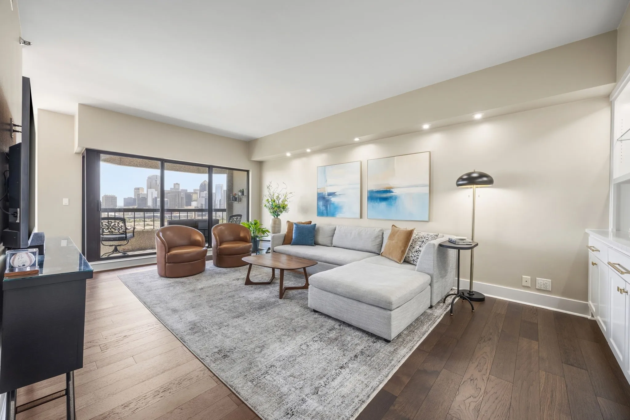 Engineered wood flooring flows throughout the condo, with its rich stain beautifully complementing and accentuating the contrast of the sophisticated wall color palette.
